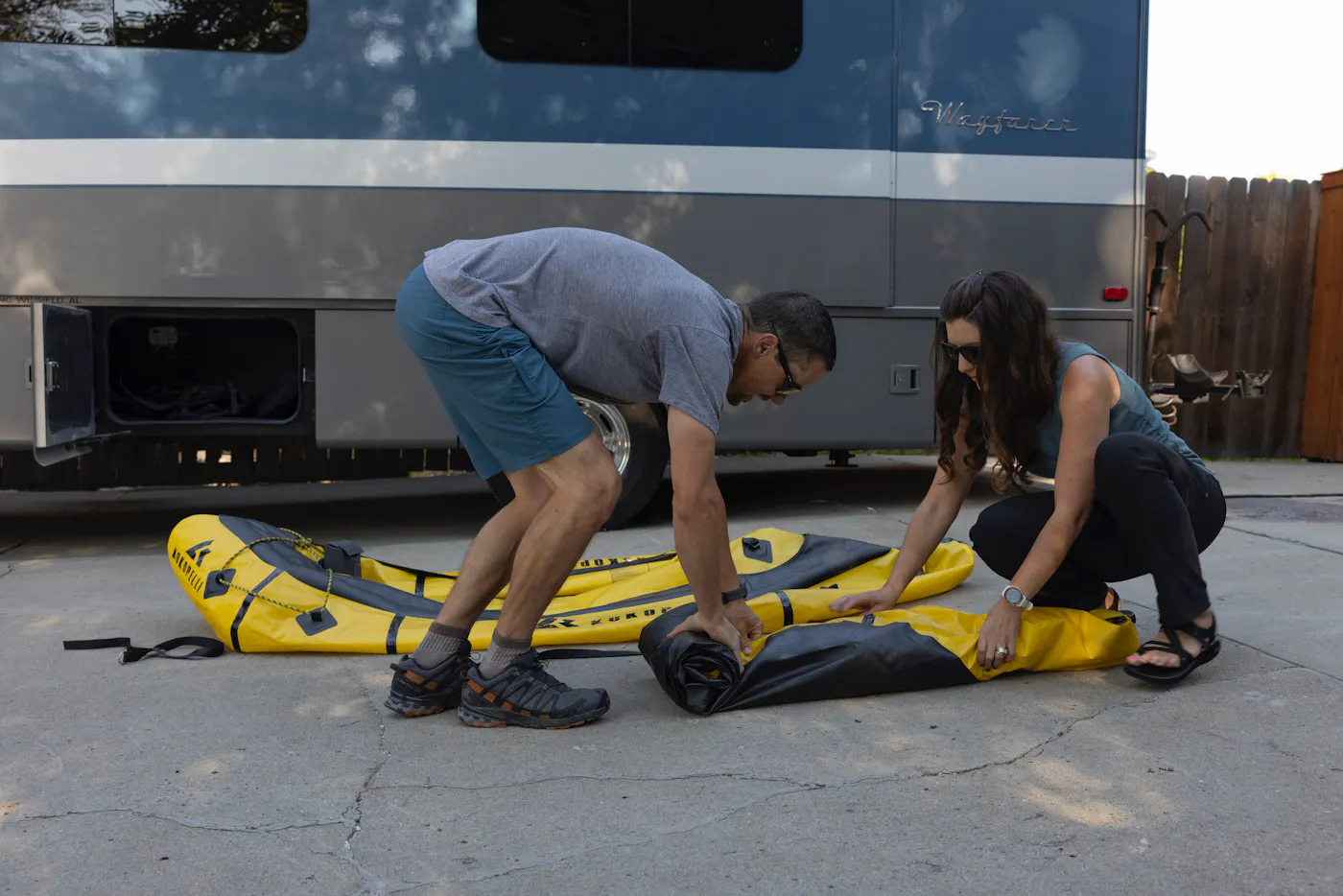 Dustin and Sarah rolling up their packrafts to put into their Tiffin Wayfarer
