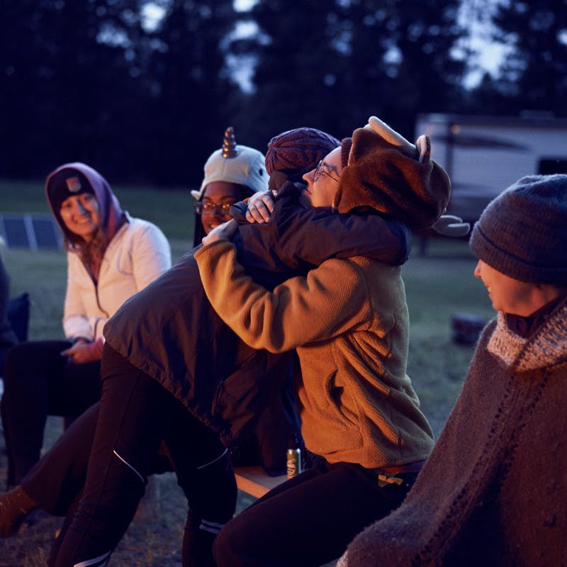 Participants hug one another at their nightly campfire.