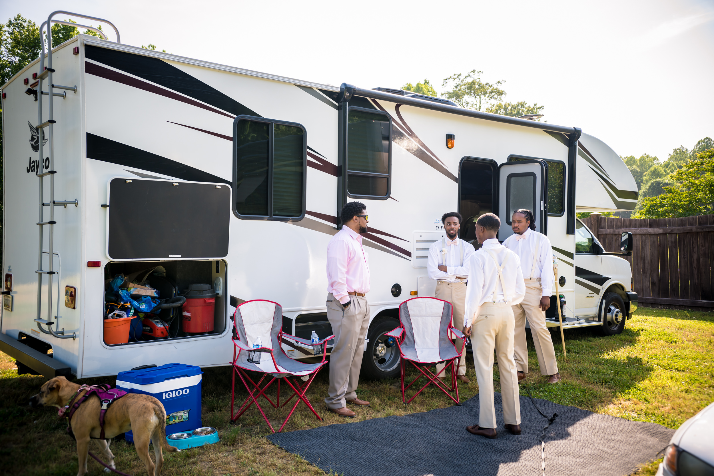 A group of groomsmen hudding in front of Sonya and Ray's class C RV.