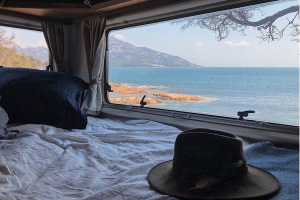 A view from the inside of an RV looking out the window to Coles Bay, in Tasmania, Australia. 