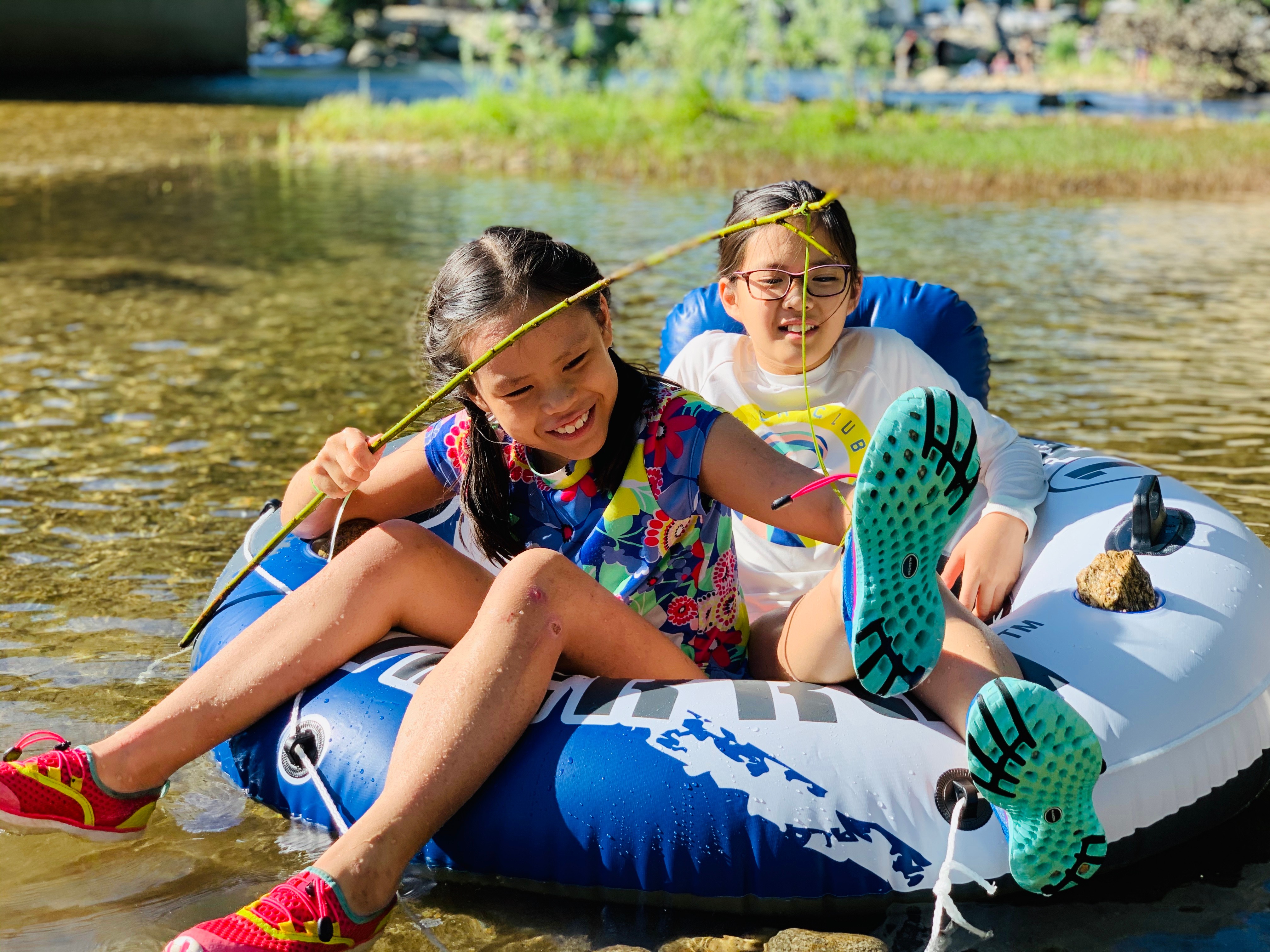 Brenda and Tiger's daughters in a creek on a pool float