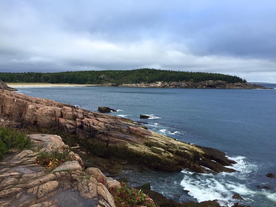 Rocky tide pools with cloud skies and small waves crashing