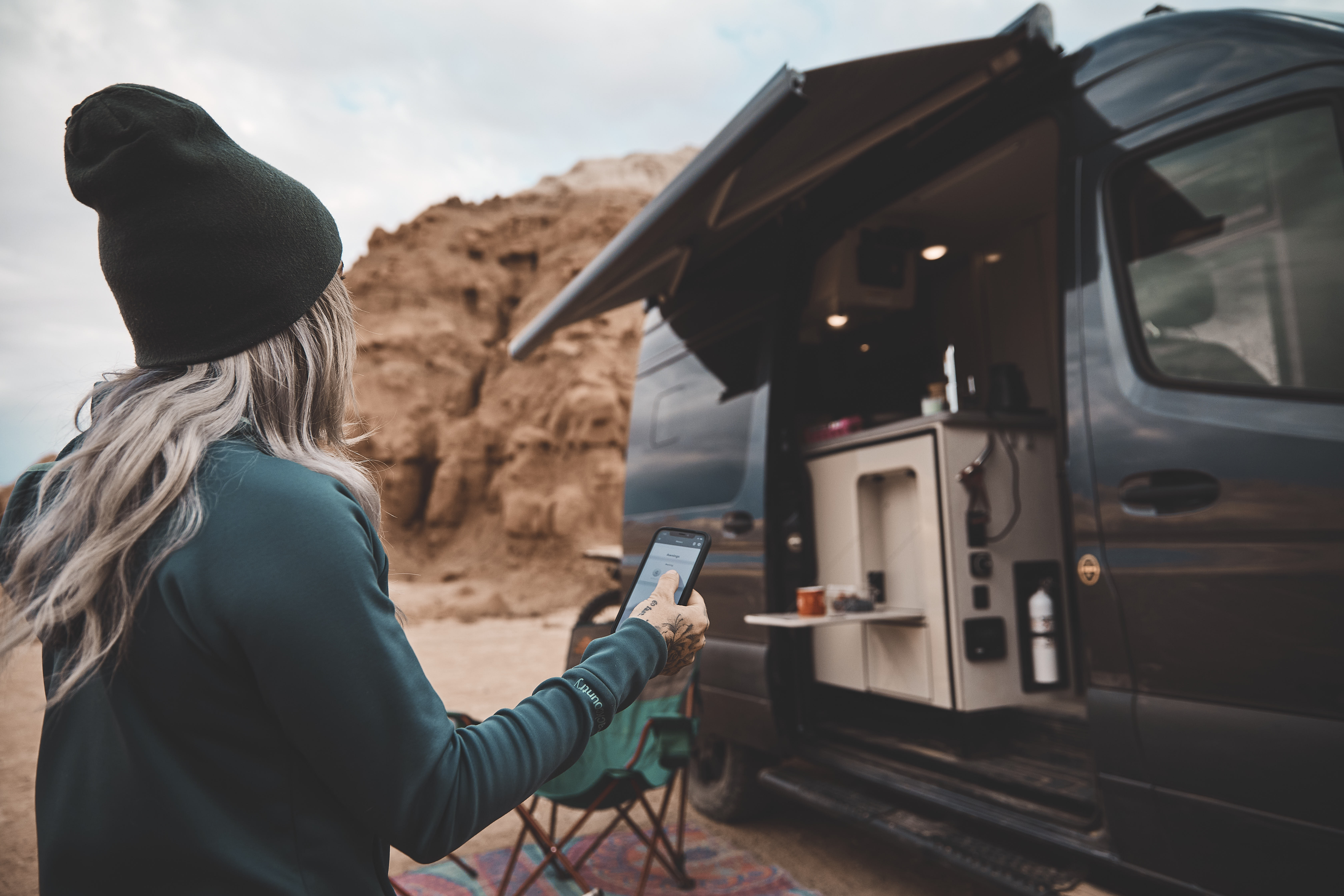 Kale Thorien uses her phone to connect to her TMC Sanctuary Class B RV.