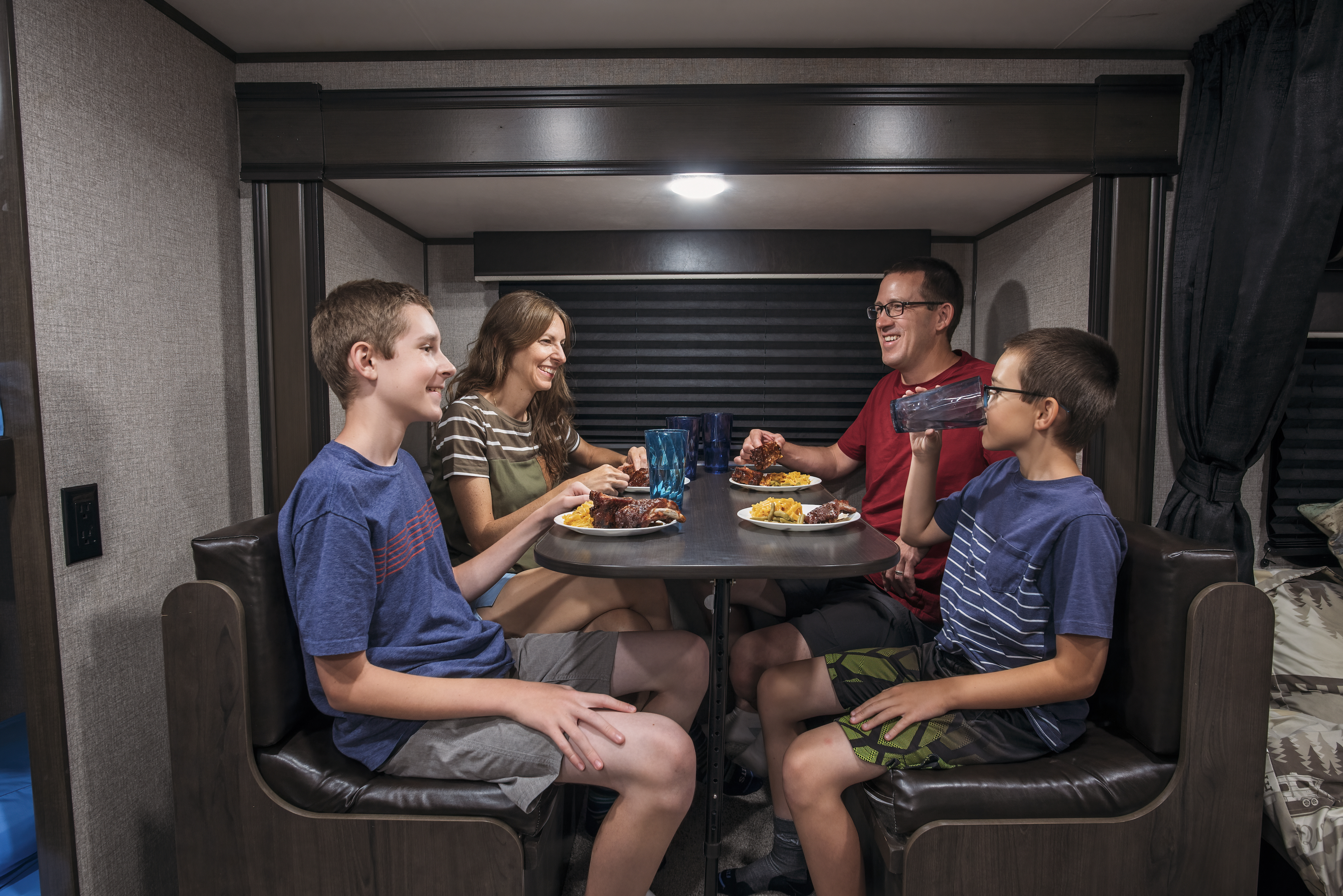 Alison Takacs and her family eating dinner at the dinette inside their RV