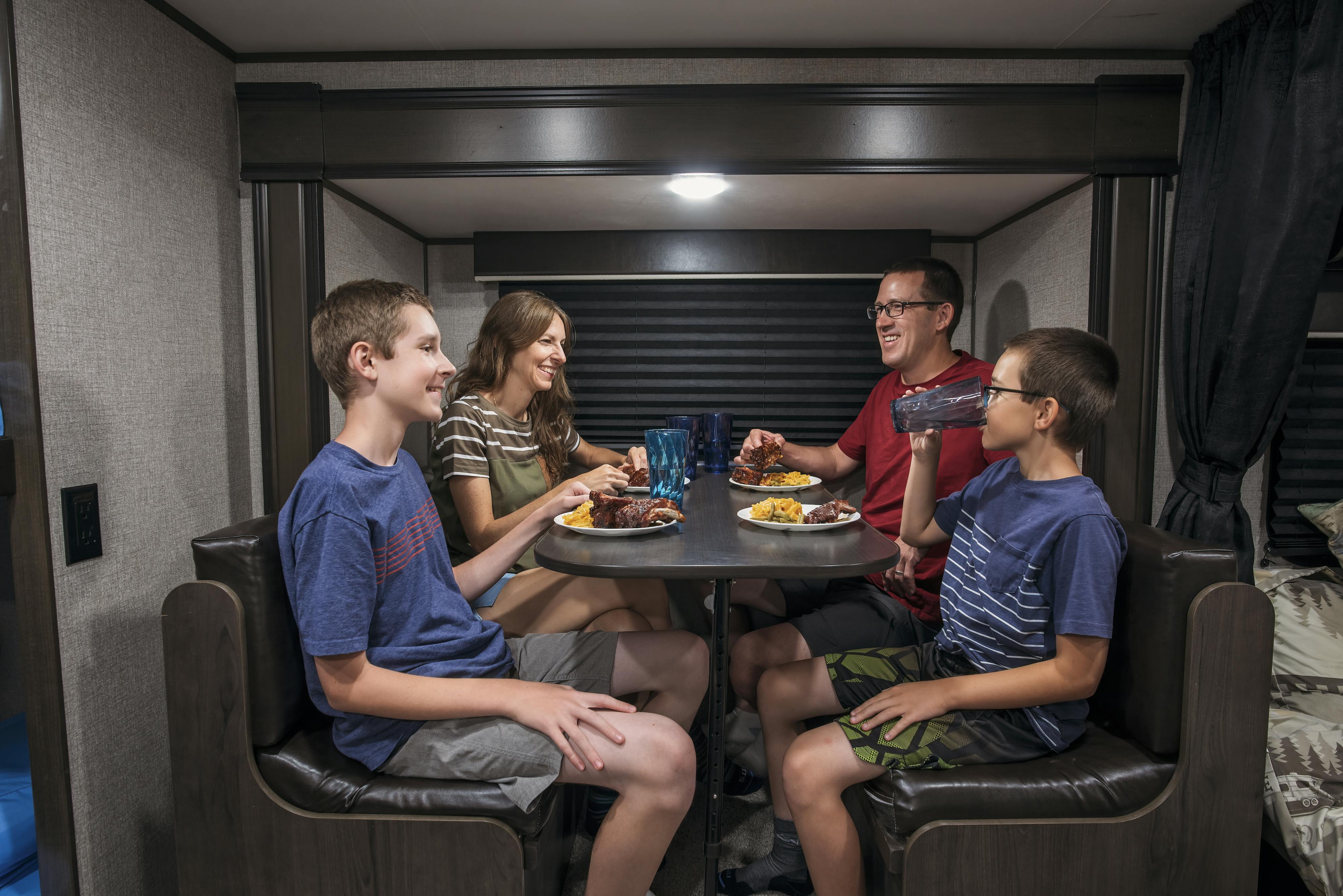 Alison Takacs and her family eating dinner at the dinette inside their RV