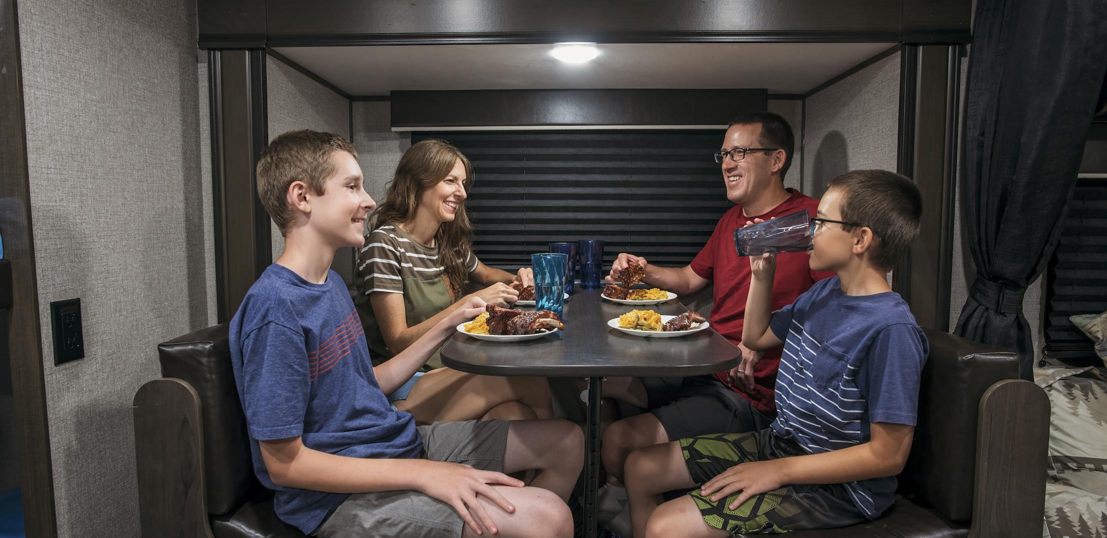 Alison Takacs and her family eating dinner at the dinette inside their RV