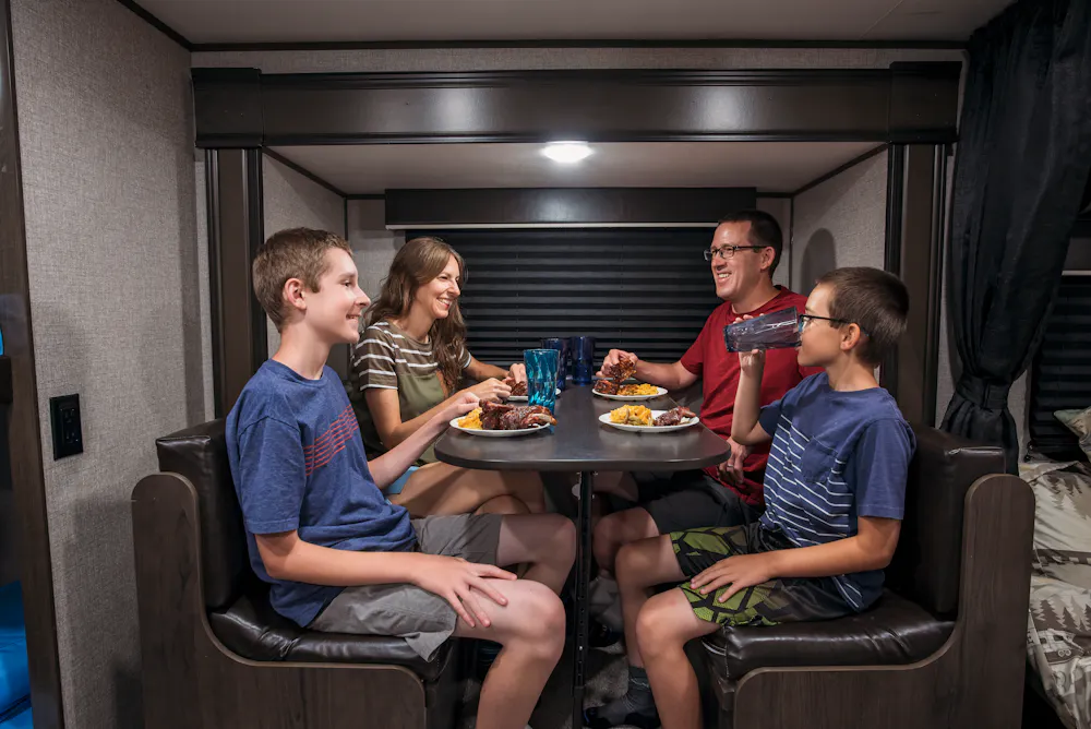 Alison Takacs and her family eating dinner at the dinette inside their RV