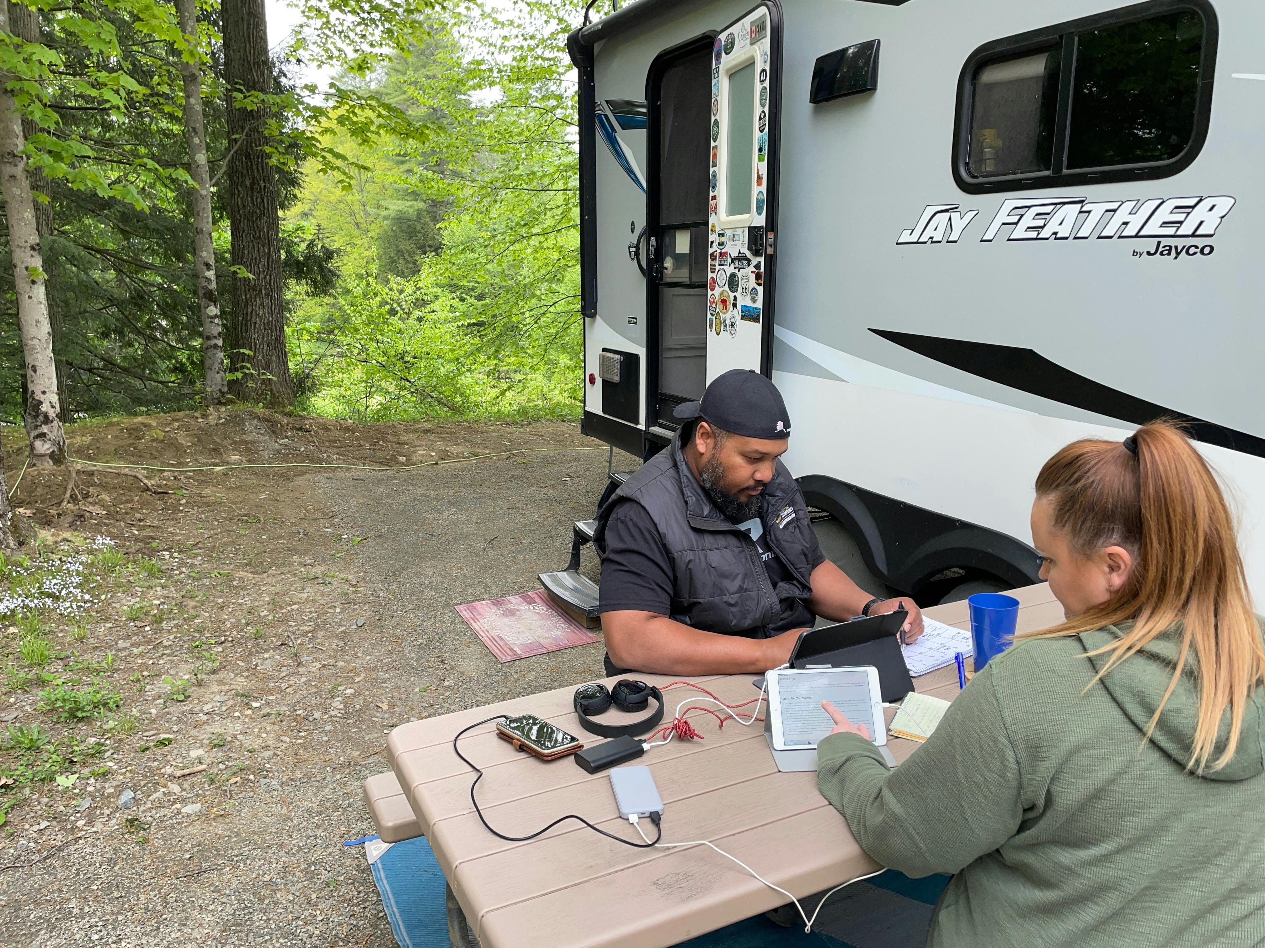 Ben and Christina charging devices outside of their RV