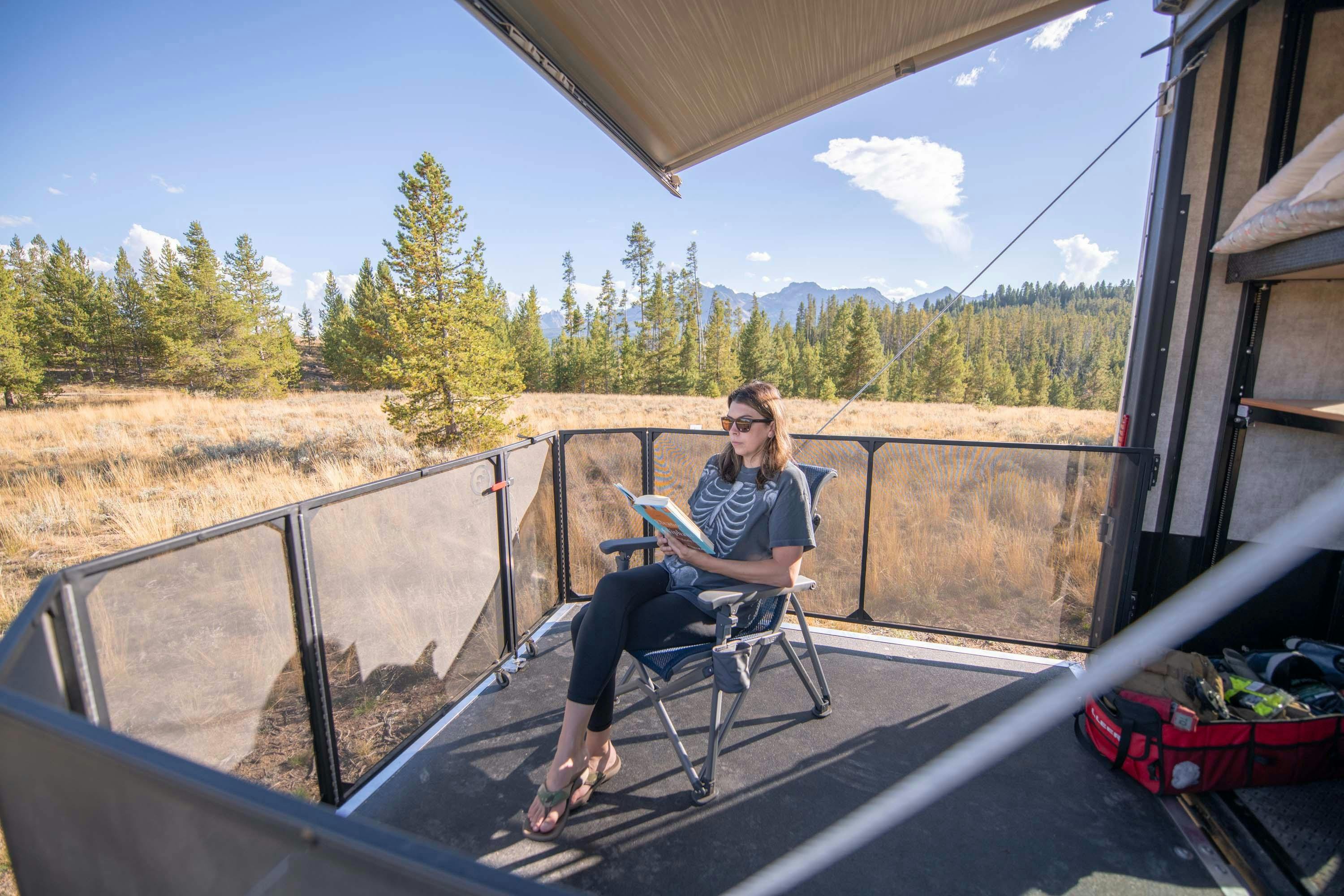 Chelsea Day reading a book in her toy hauler at Sawtooth National Forest