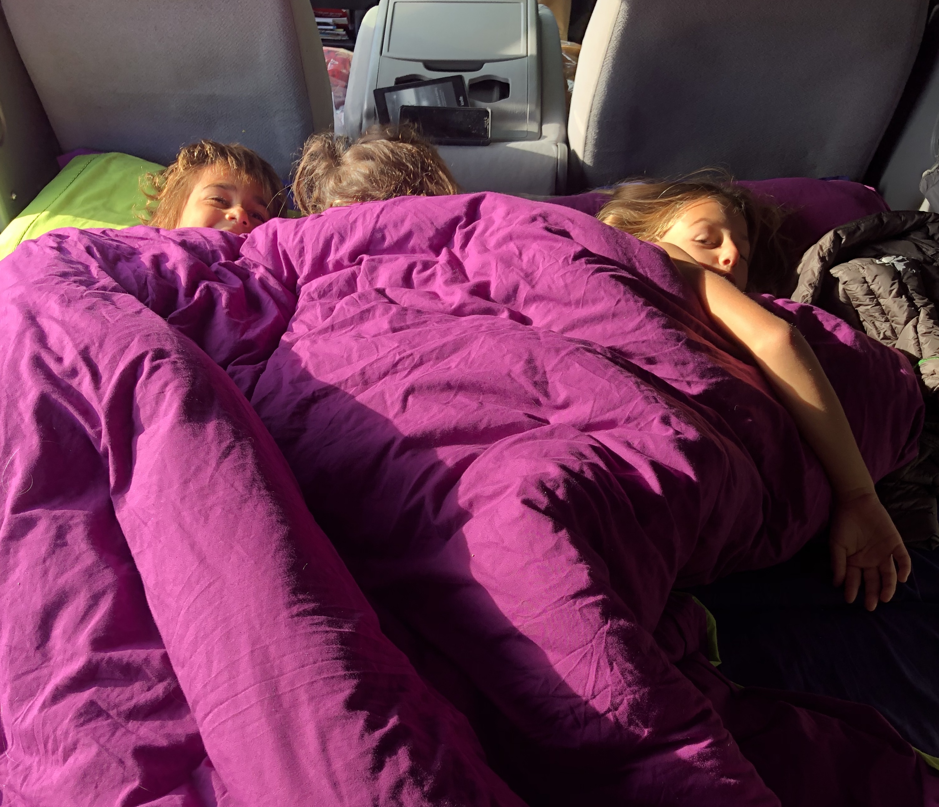 LAURA GEORGIEFF's kids snuggled in the class b van