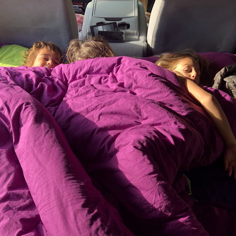 LAURA GEORGIEFF's kids snuggled in the class b van
