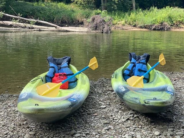 Brandy Gleason's kayaks at the edge of a lake