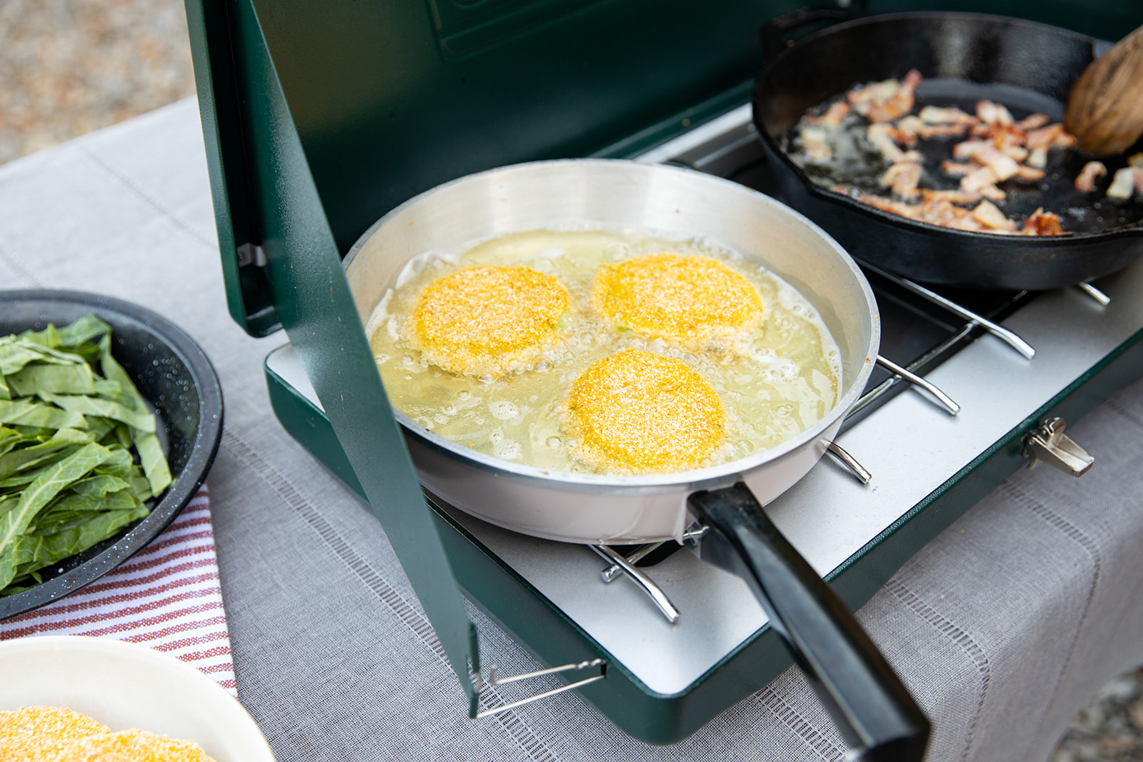 Green tomatoes frying in a pan. 