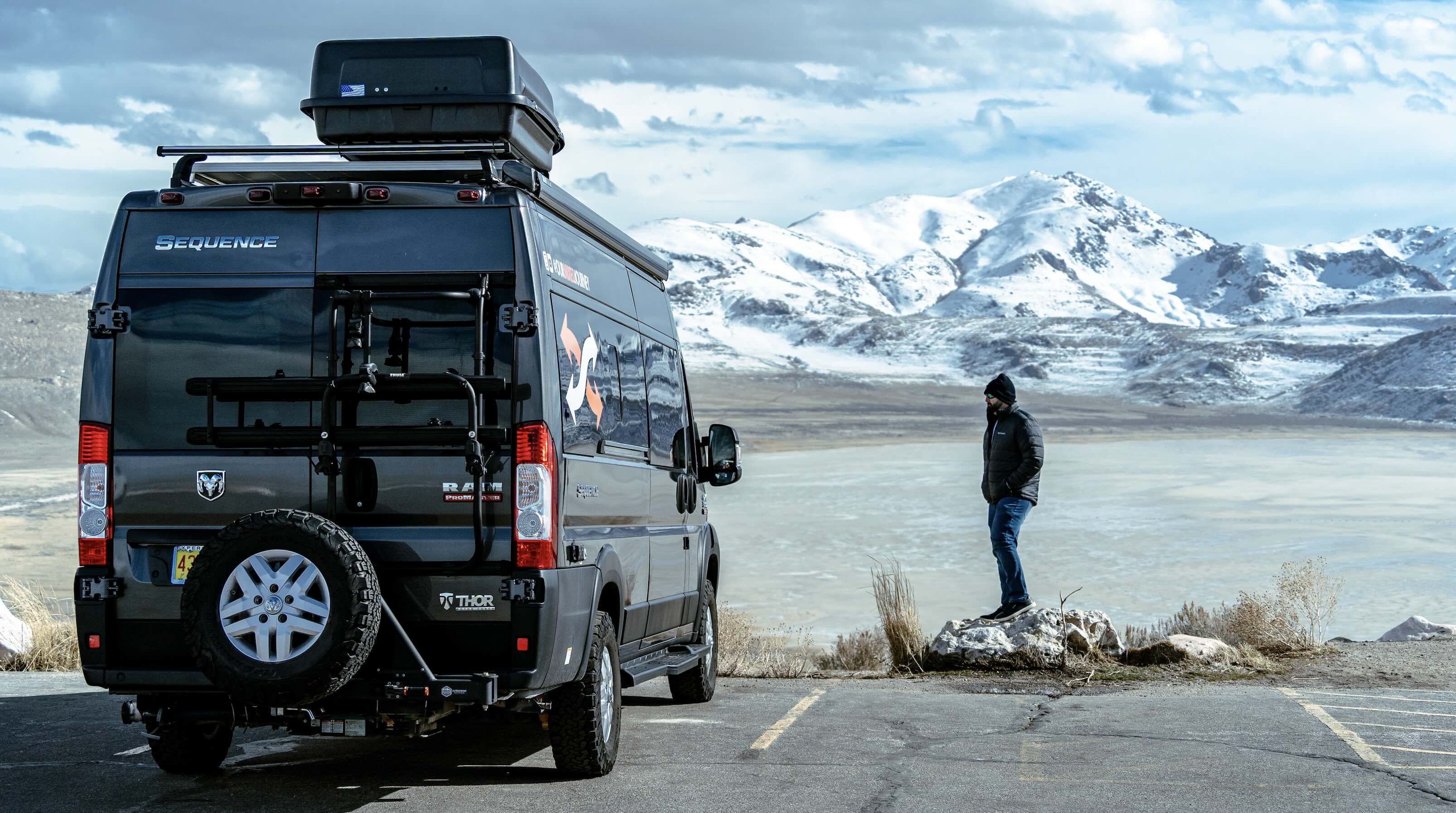 Gabe Rivero standing outside of his 2021 Thor Motor Coach Sequence 20L overlooking the mountains