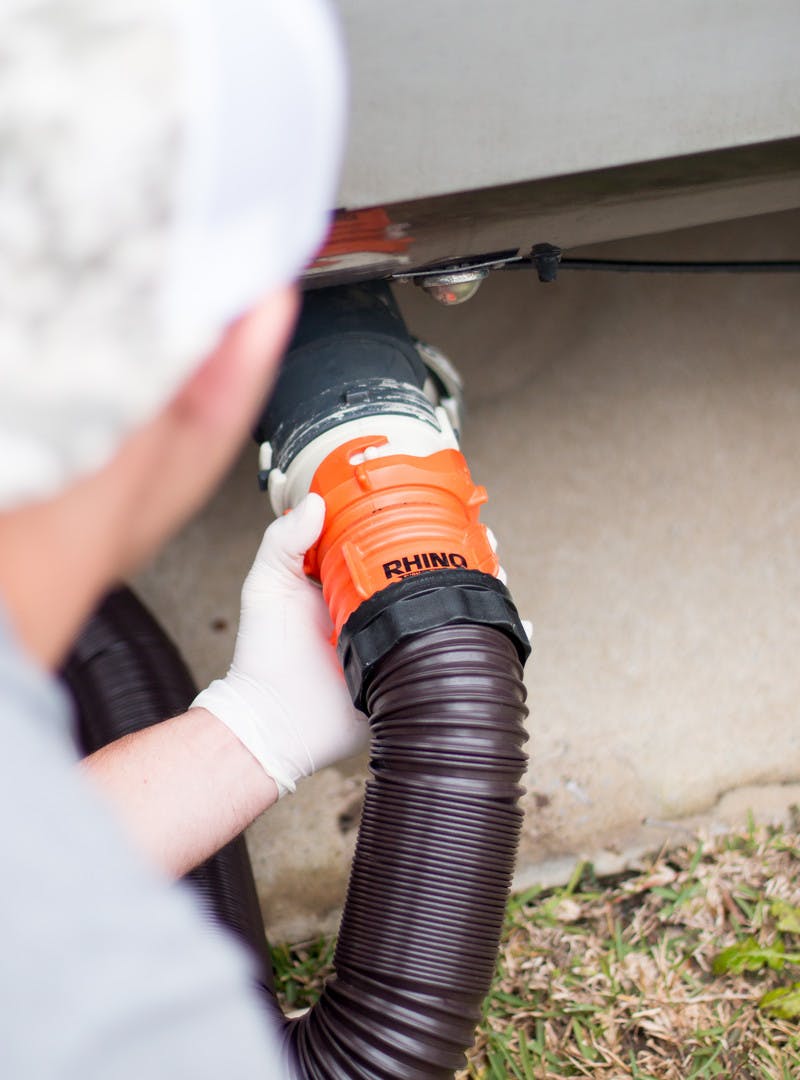 A man locking the waste hose into place. 