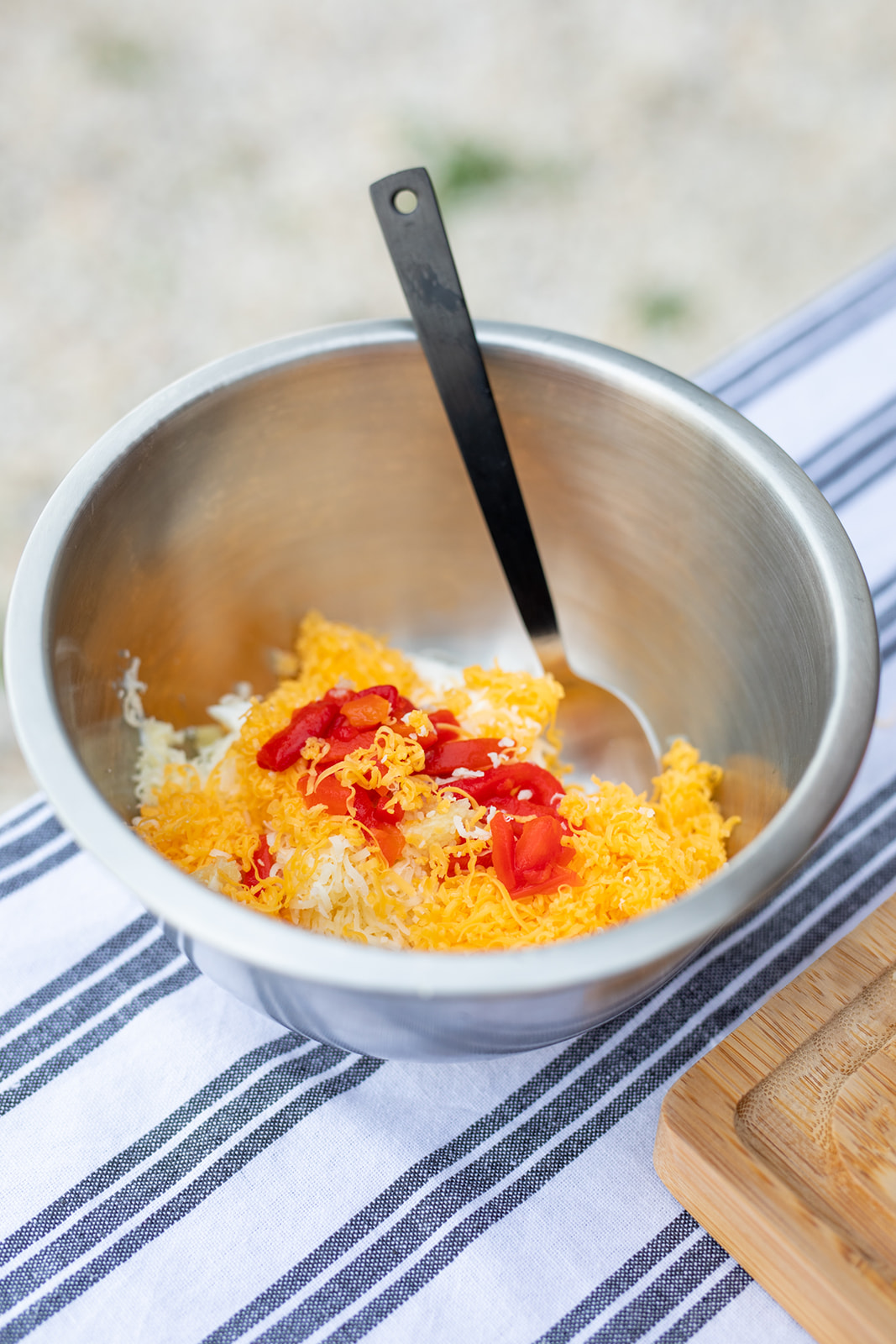 Mixing cheese and pimentos together in a bowl.