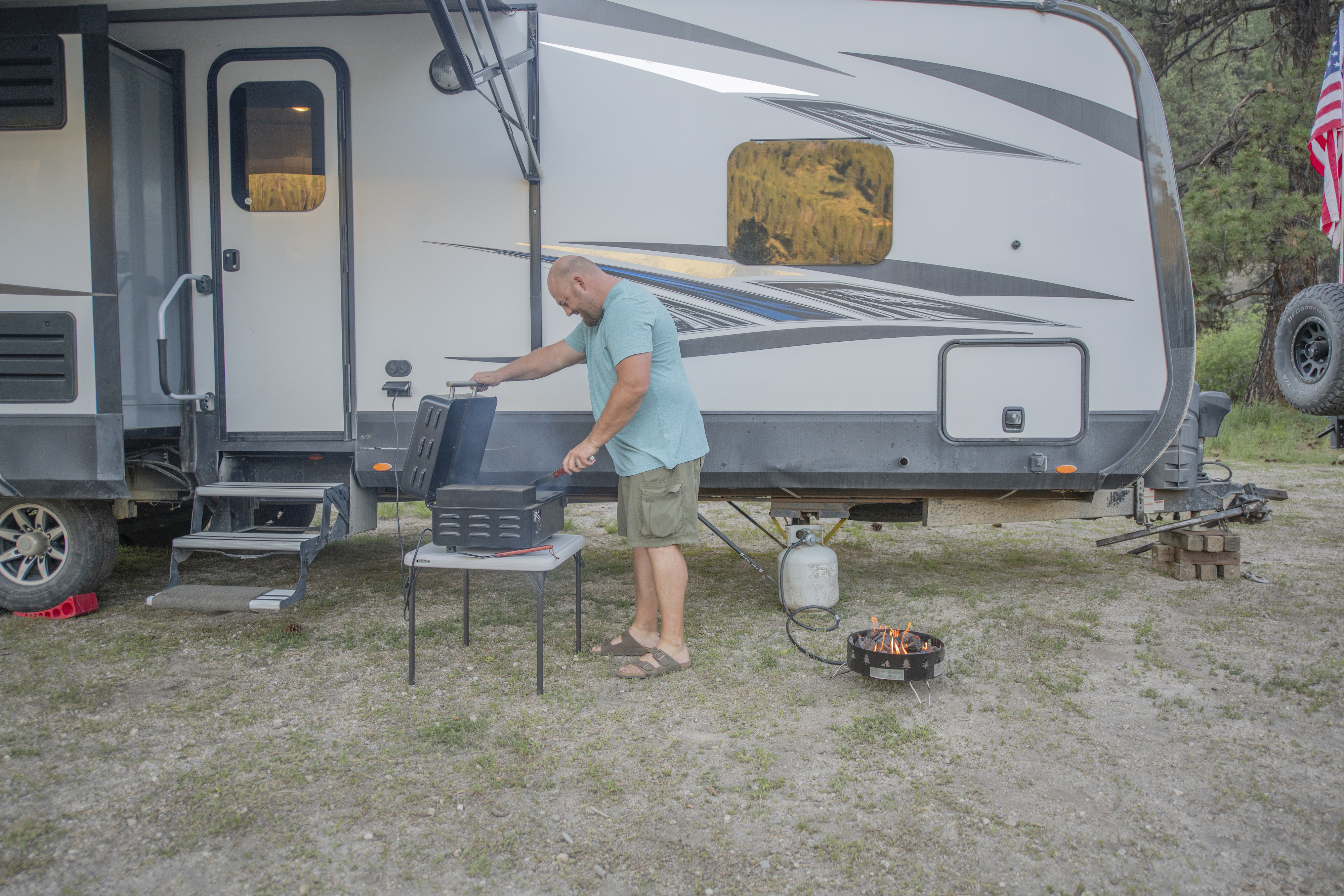 Nate Day grilling outside next to his Highland Ridge RV.
