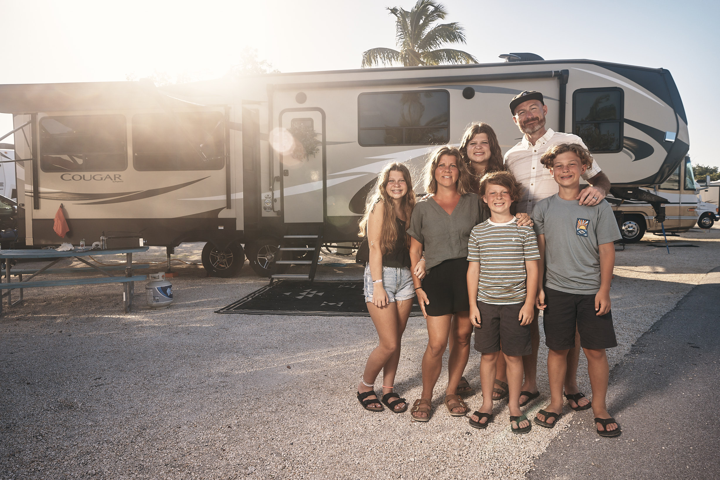The Lane family pose for a family photo in front of their Keystone Cougar RV