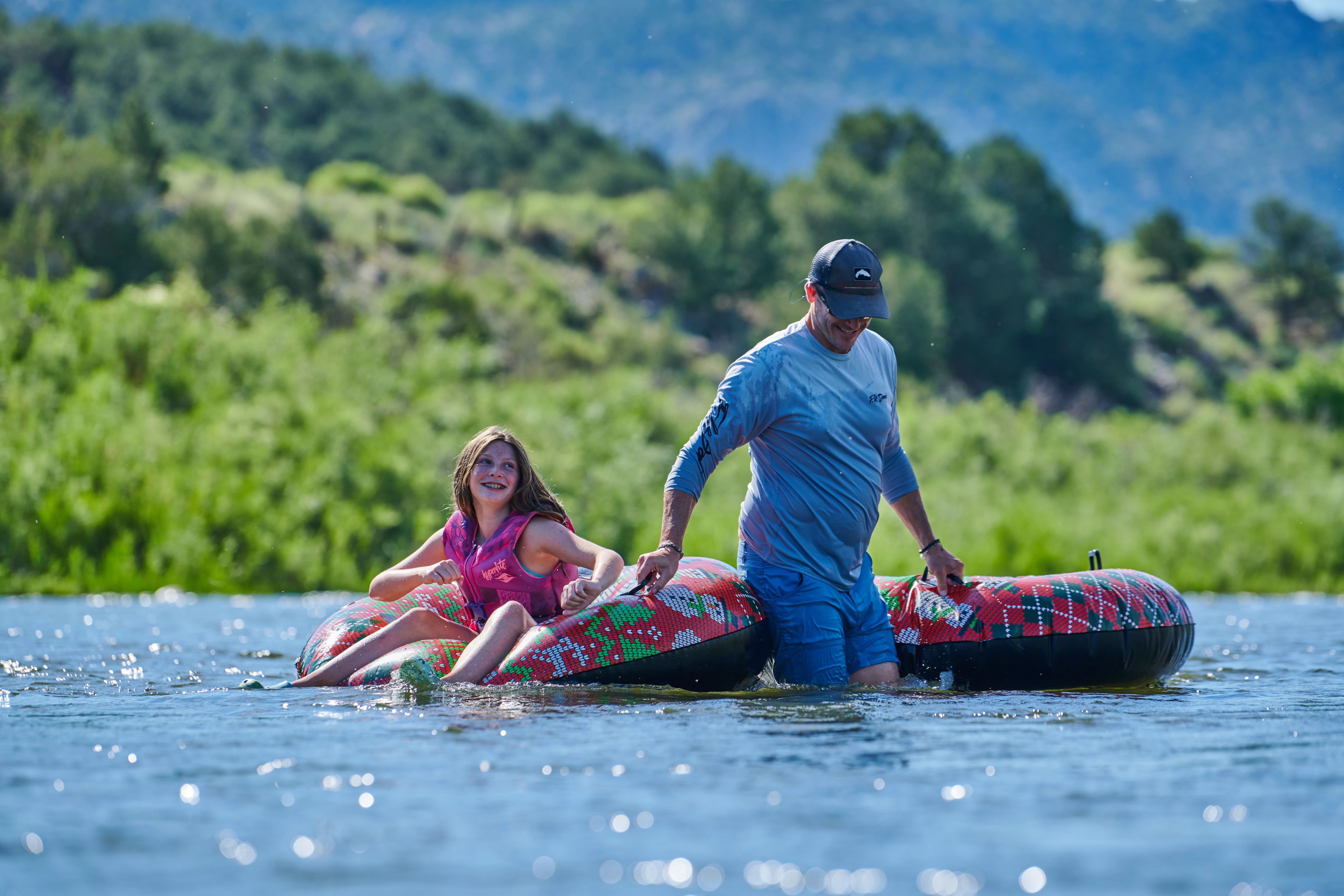 Chris Heublein playing with his daughter in a river