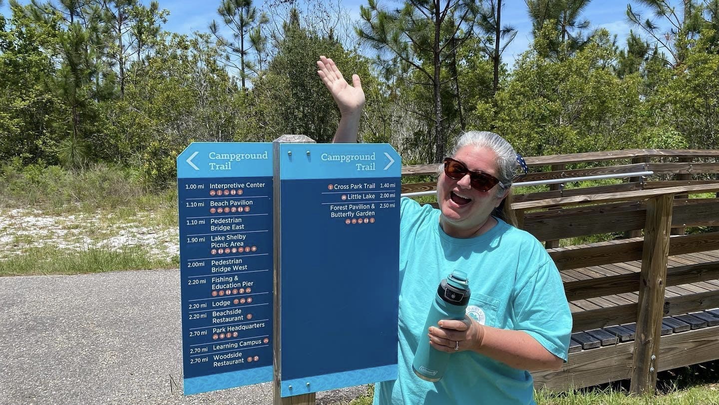 Tiffany Dunagan posing next to a campground trail map