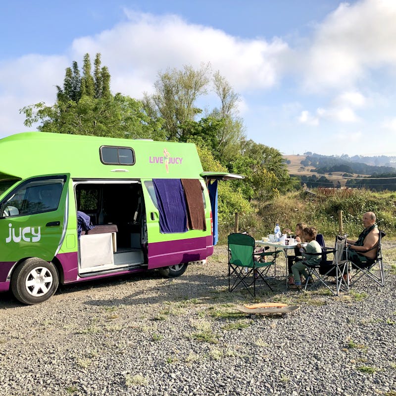 LAURA GEORGIEFF's family sitting outside of a rented Class B RV