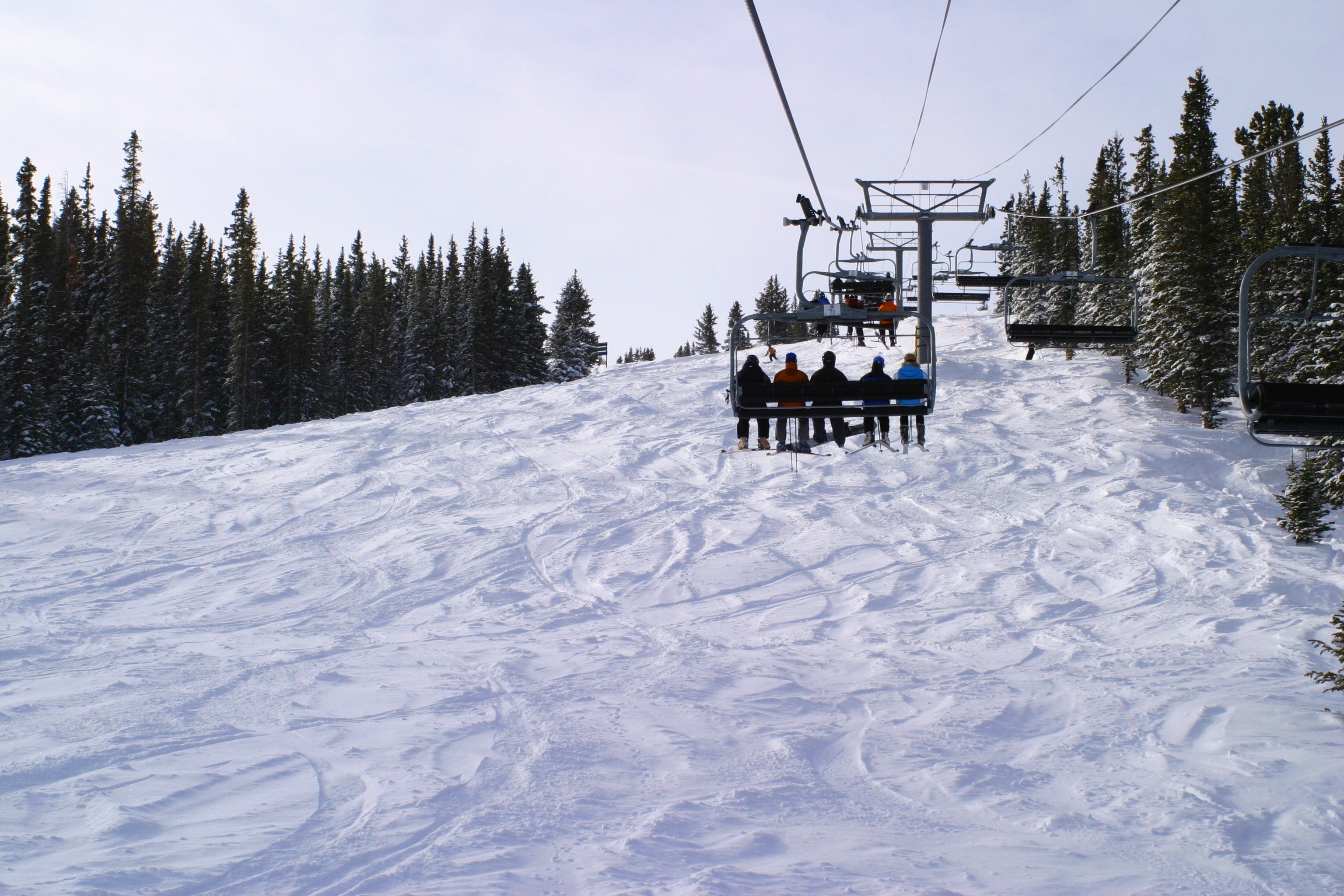 A chair lift carrying people up Copper Mountain. 