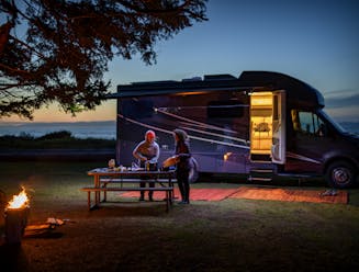 Chelsea and Layla cook dinner at dusk outside of a Tiffin Wayfarer RV