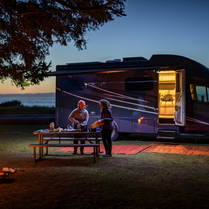 Chelsea and Layla cook dinner at dusk outside of a Tiffin Wayfarer RV