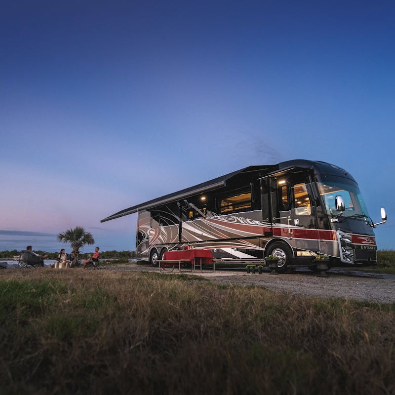 An Entegra Class A motorhome parked by the beach