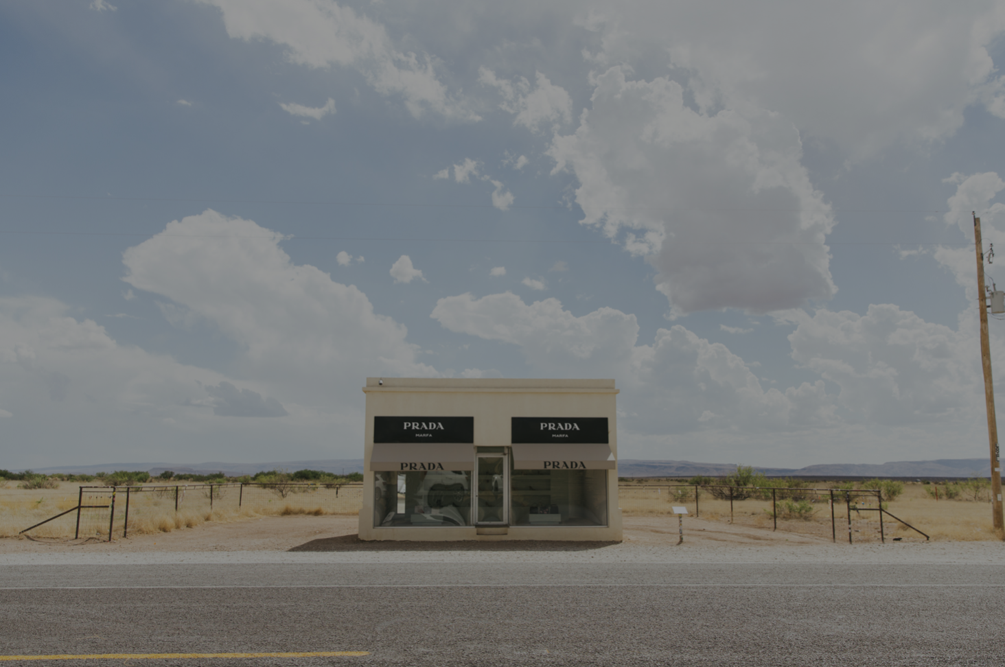 Prada Marfa building on a bright day against blue sky and clouds