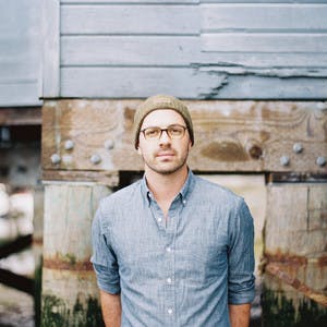 A headshot of Jeffrey Shipley standing in front of a wall. 