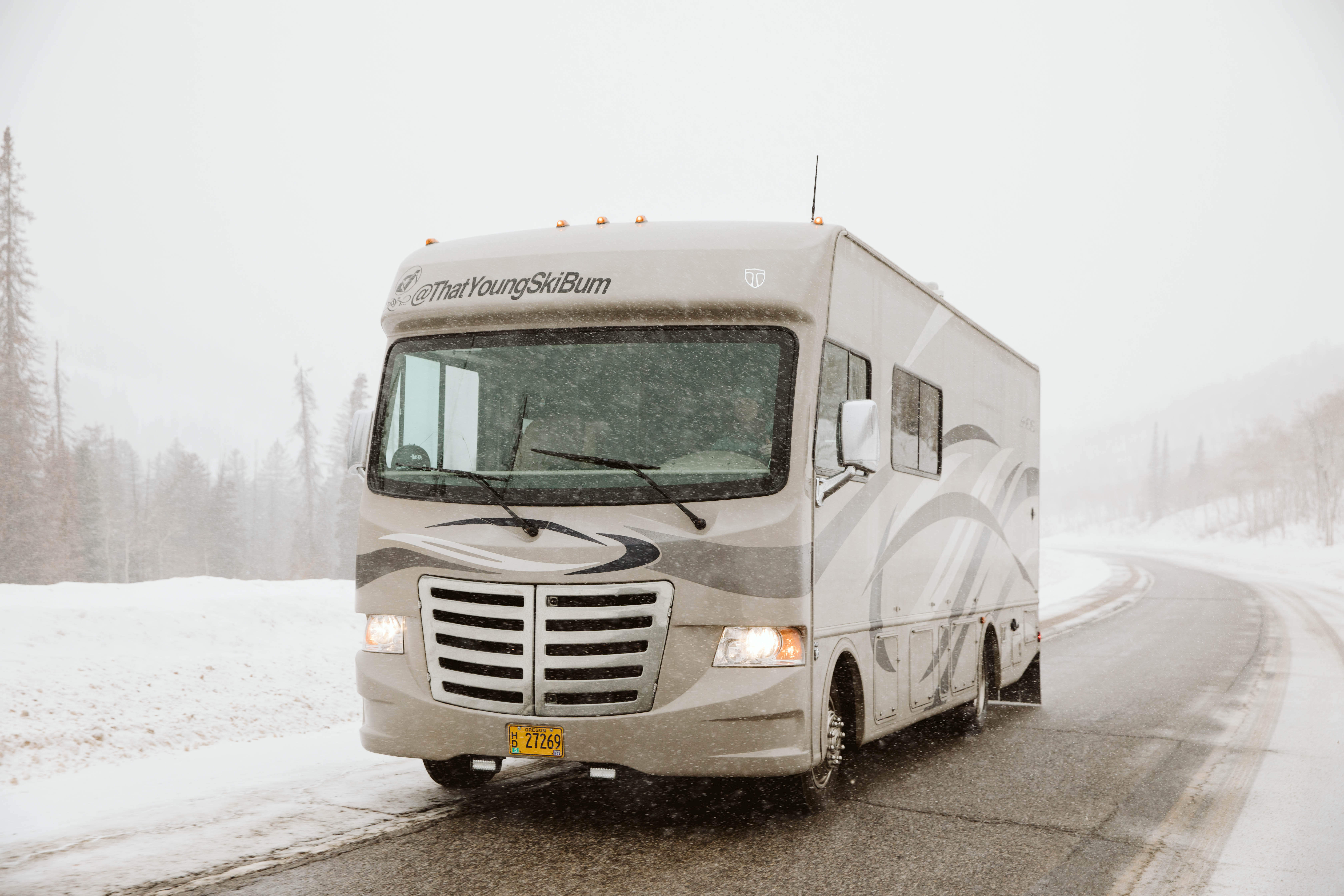 An RV on the road in the snow. 