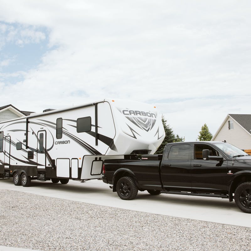 Exterior shot of a truck hitching a toy hauler RV in the driveway of Steve and Suzanne Talbot's home.