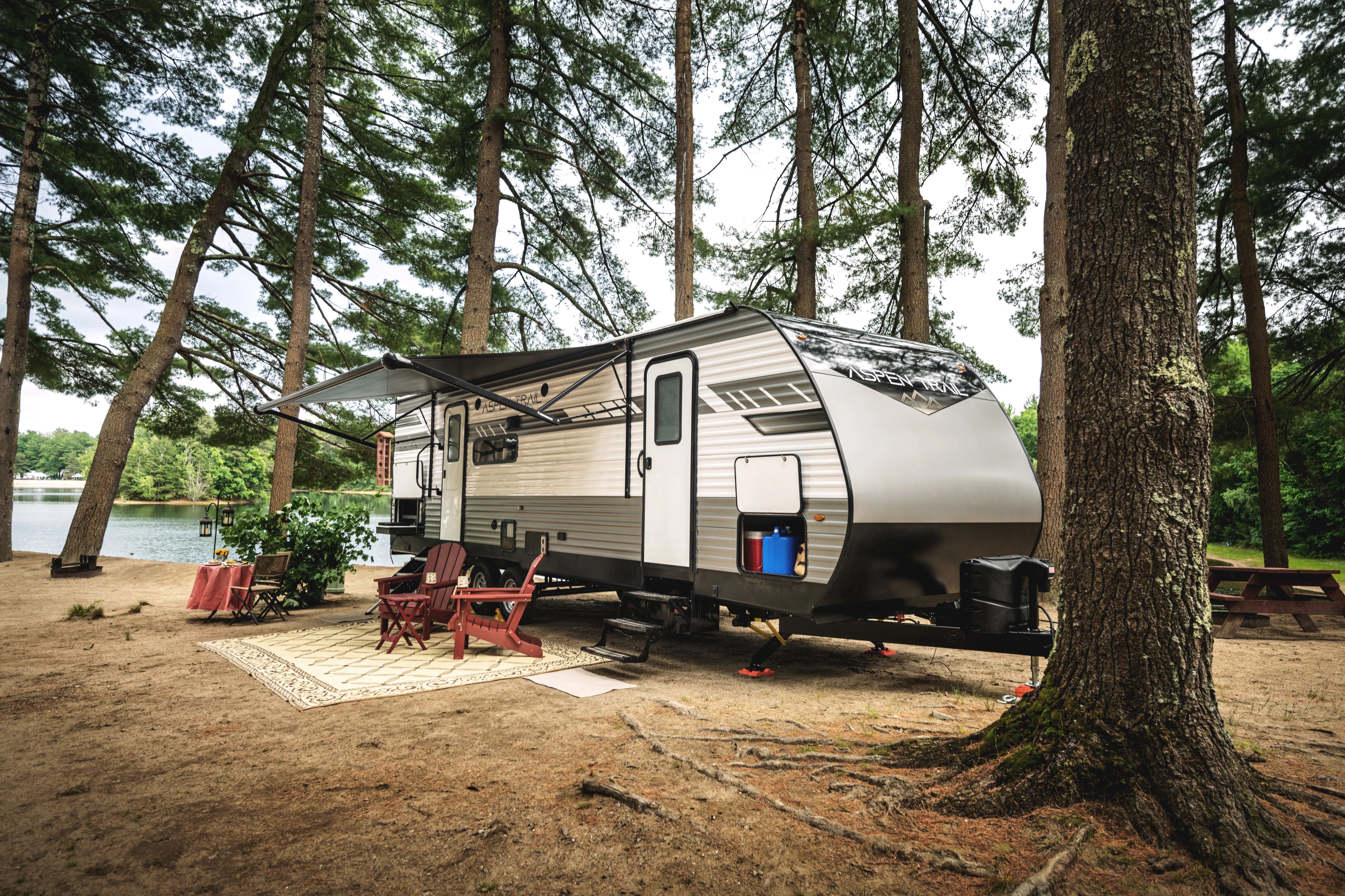 A travel trailer parked by a lake 