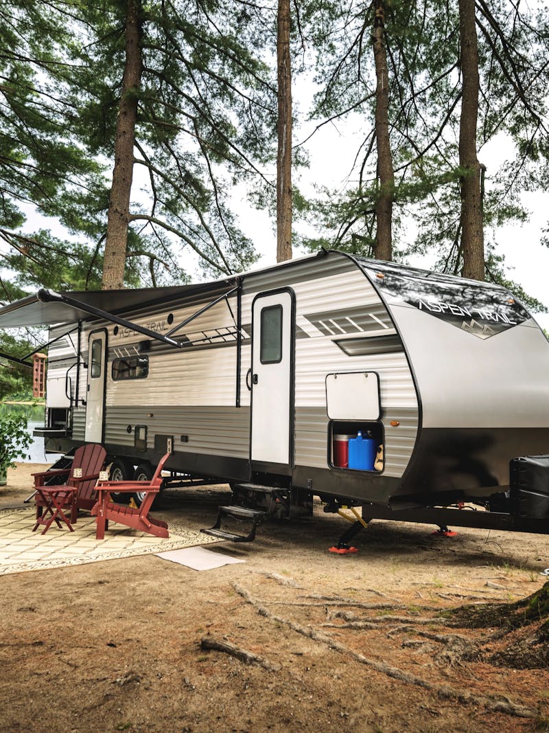 A travel trailer parked by a lake