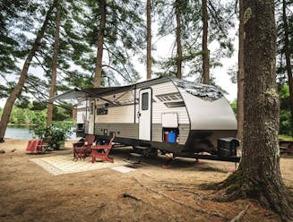 A travel trailer parked by a lake