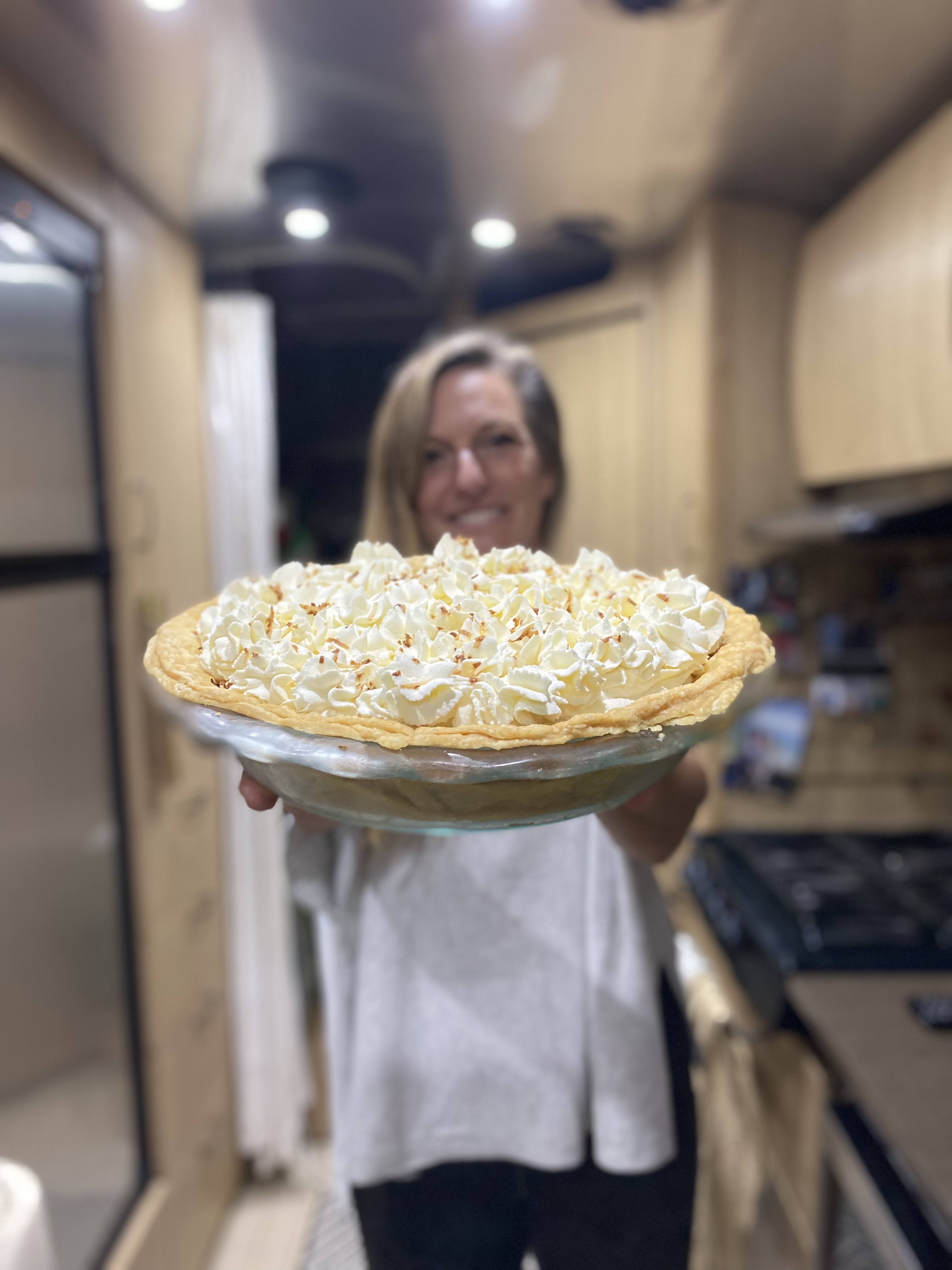 Karen Blue holding up a thanksgiving pie she made inside her Airstream