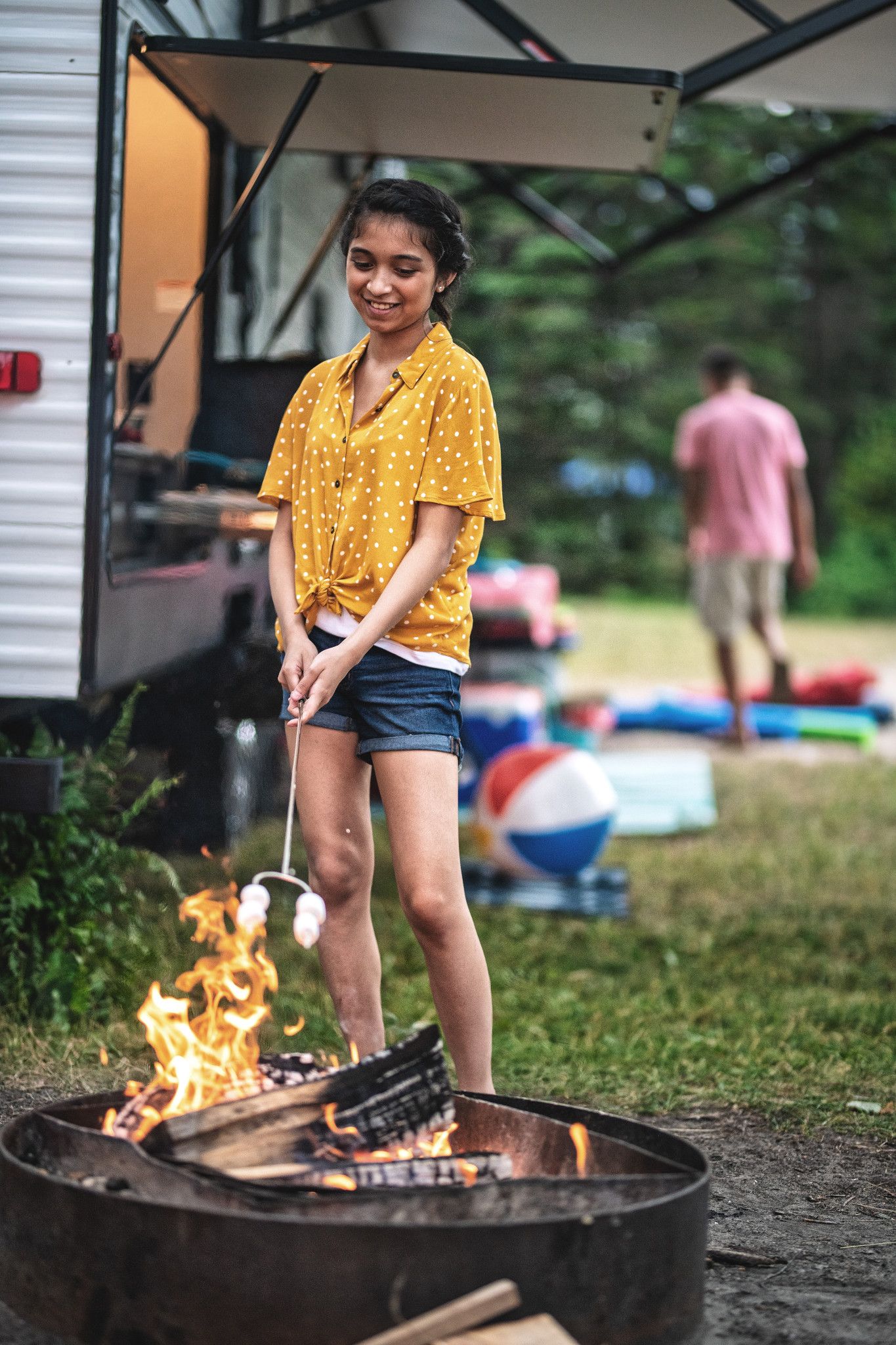 a girl roasting marshmallows over a fire