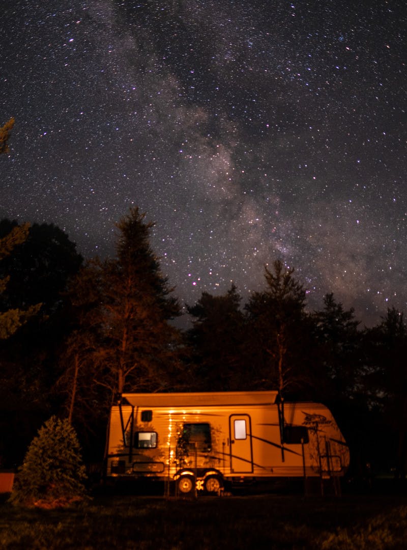 Exterior shot of a Jayco travel trailer RV at night under a starry night. 