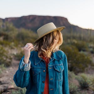 Close up shot of Natalie Allen looking off in the distance of a desert. 