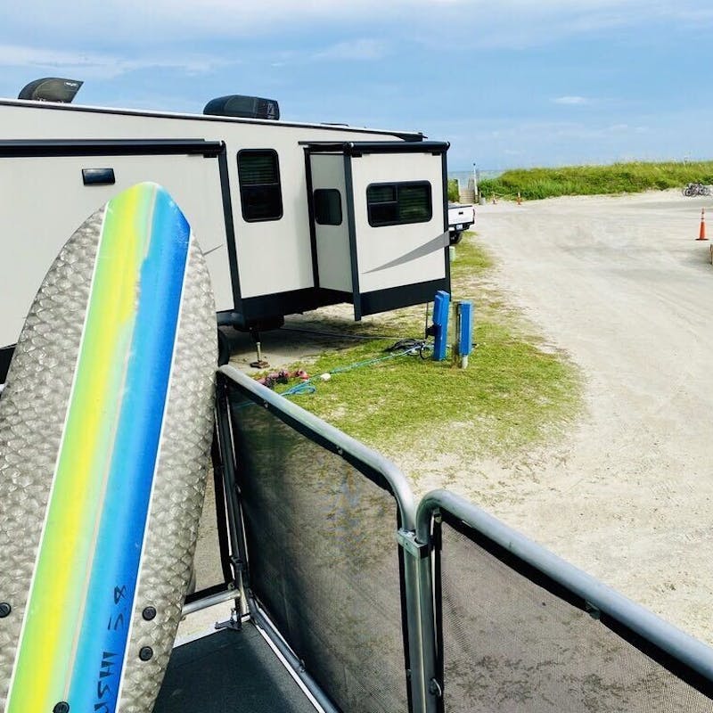 Eric Hannan's RV parked in a sandy campsite.