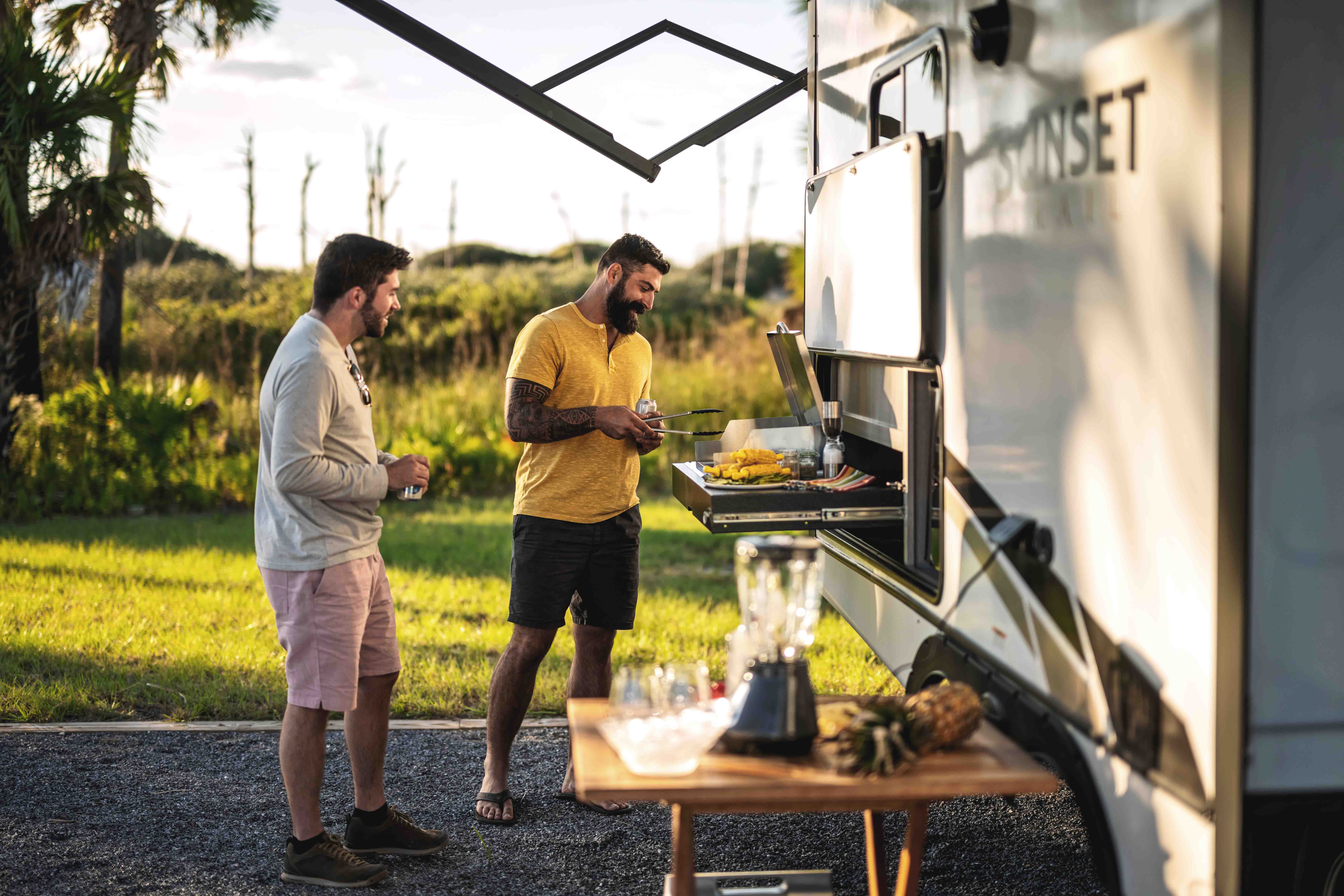 Two friends use the outdoor grill on a Crossroads Sunset Trail.