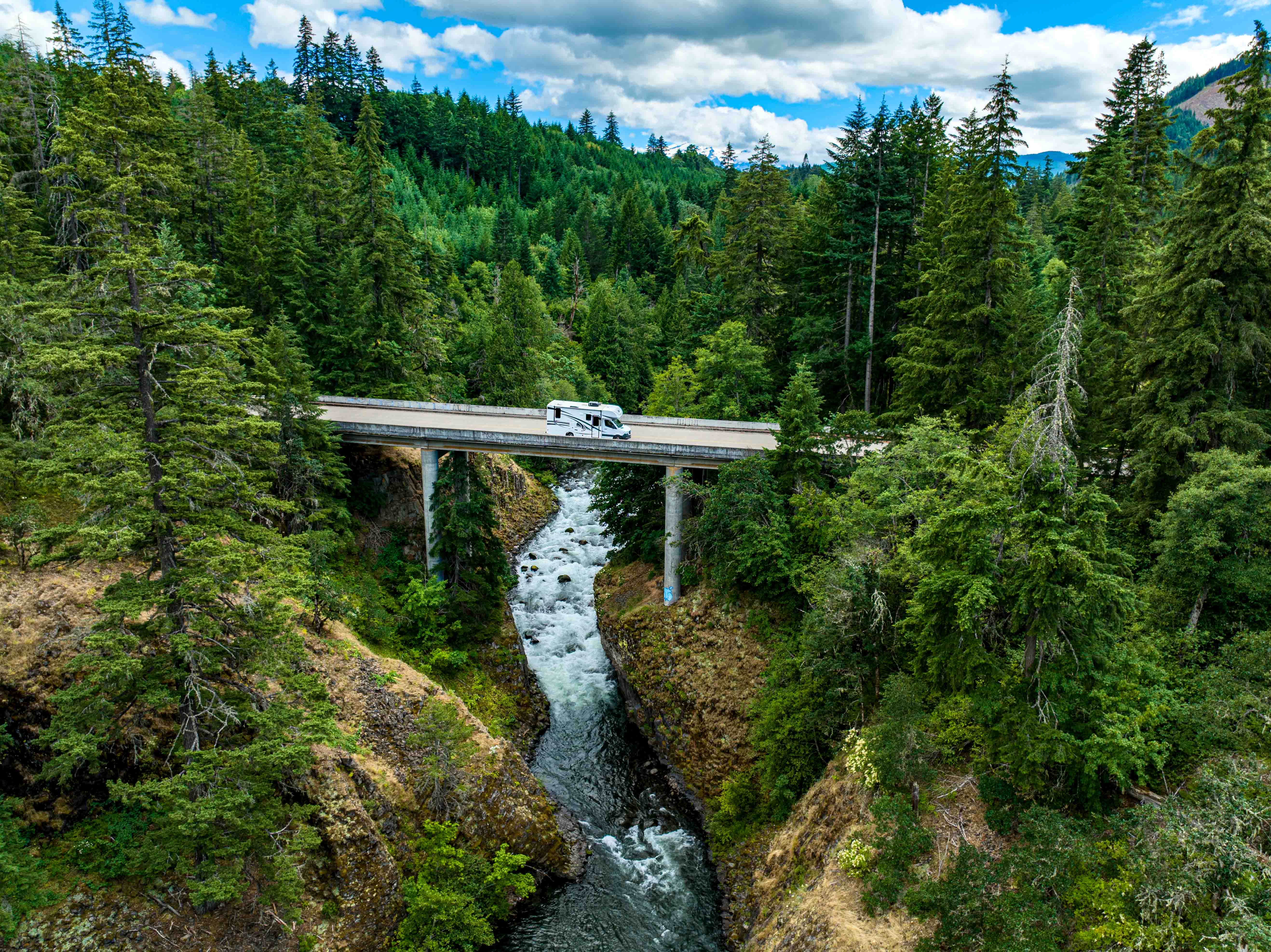 A Jayco Melbourne Class C motorhome driving across a bridge.