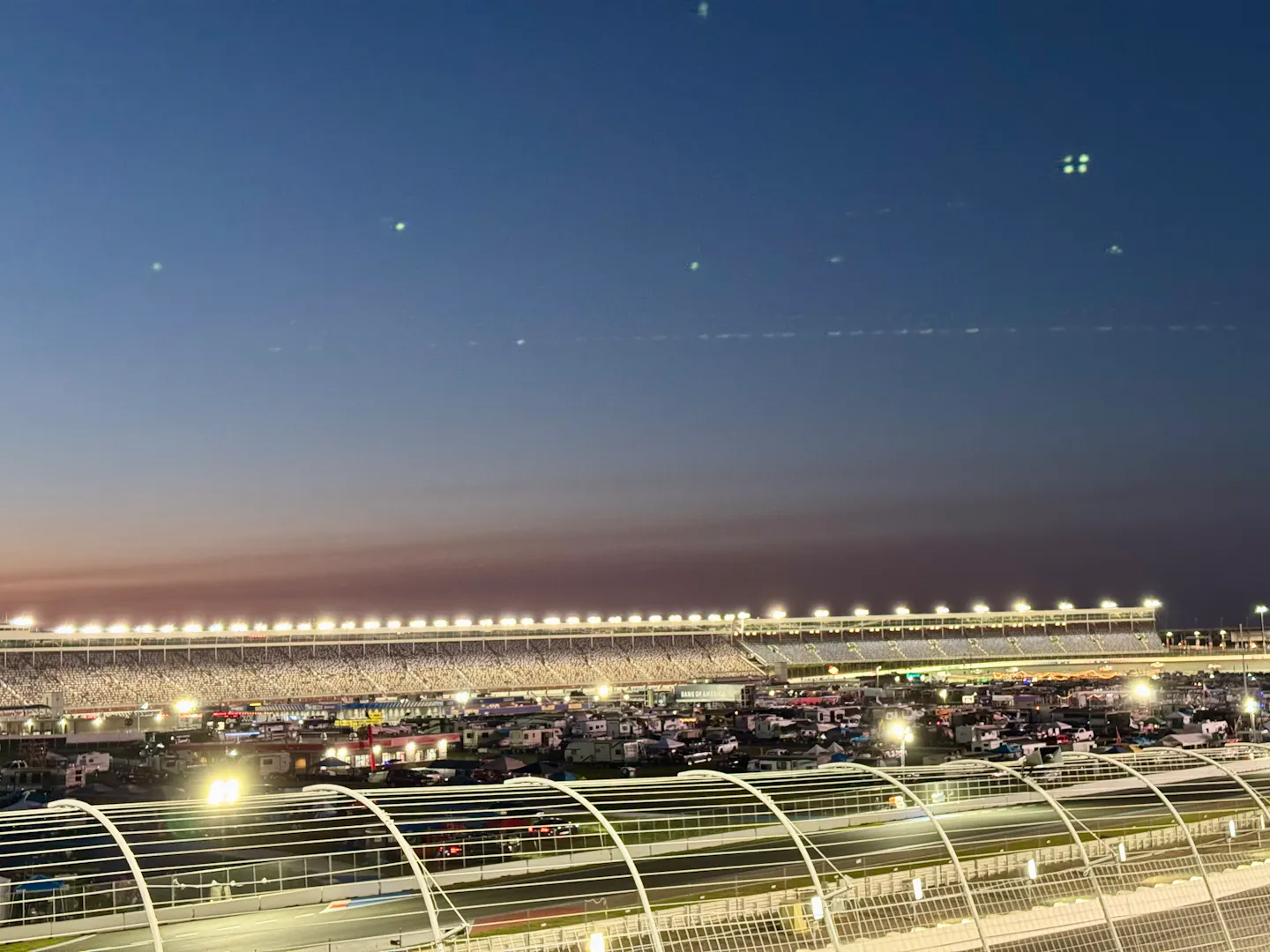 A view of the racetrack and infield RV camping at the Charlotte Motor Speedway at night.