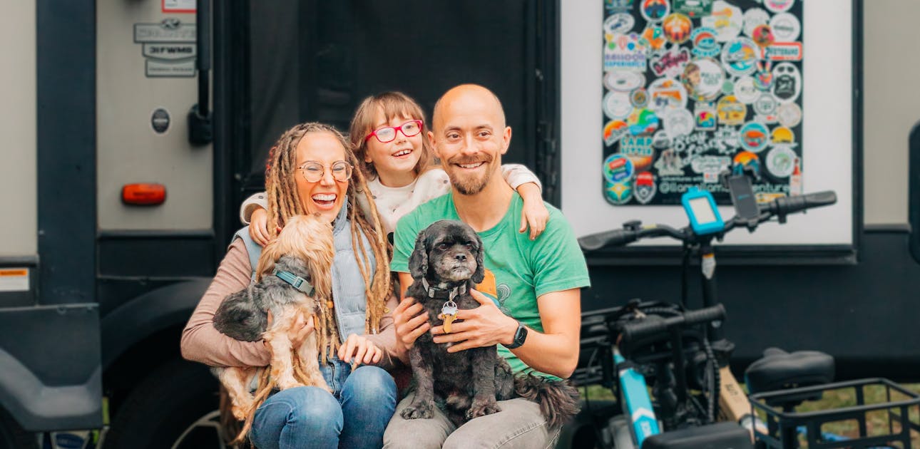 Lia and Trevor Eyre with their kid and pets next to their RV.