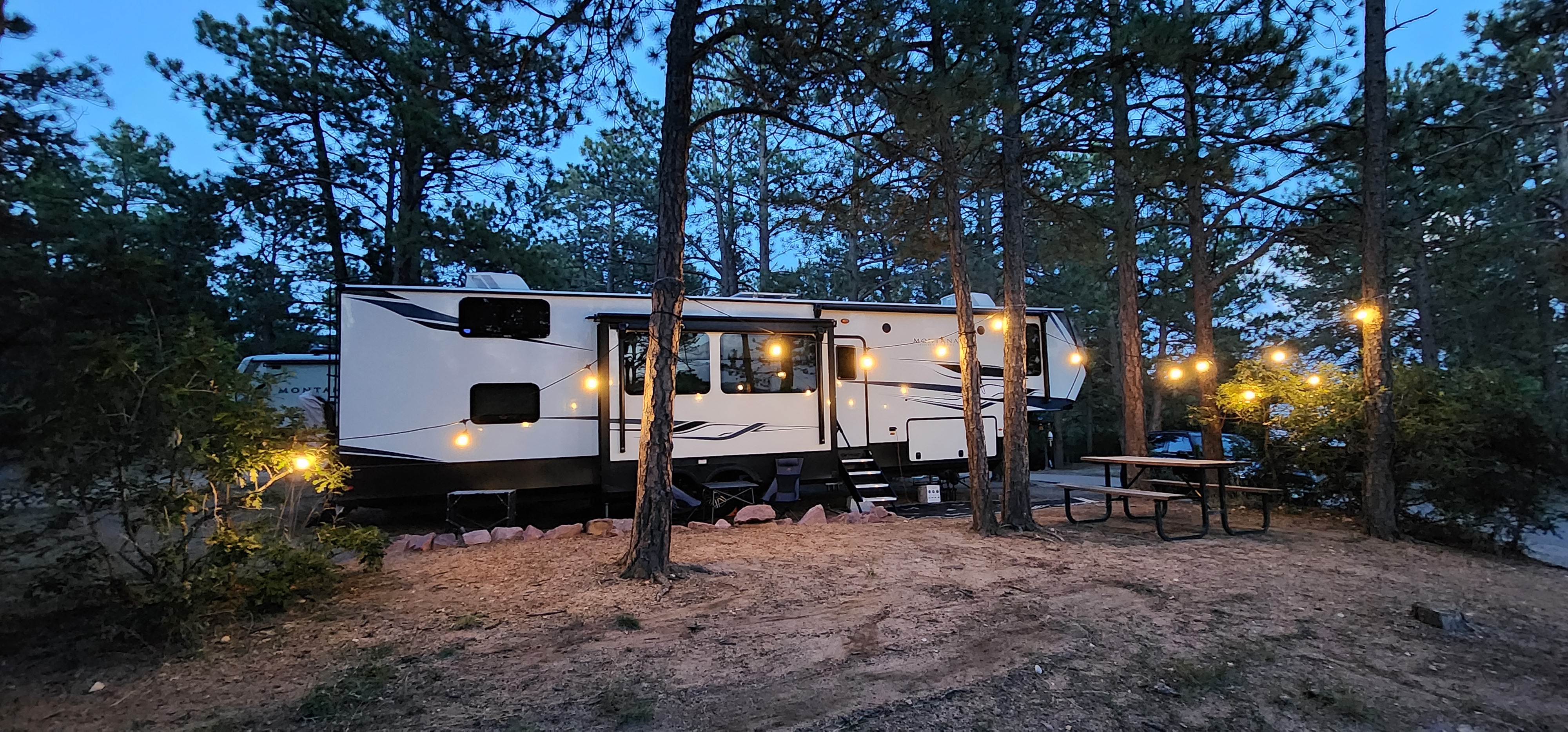 Kaylee and Steve Techau's Keystone Montana High Country fifth wheel at a campsite at night.