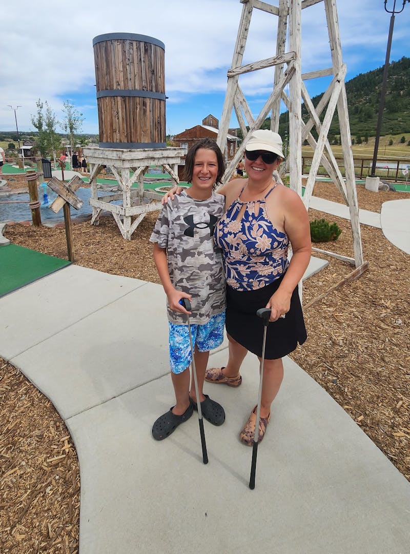 Kaylee Tachau poses with her child at a mini golf course.
