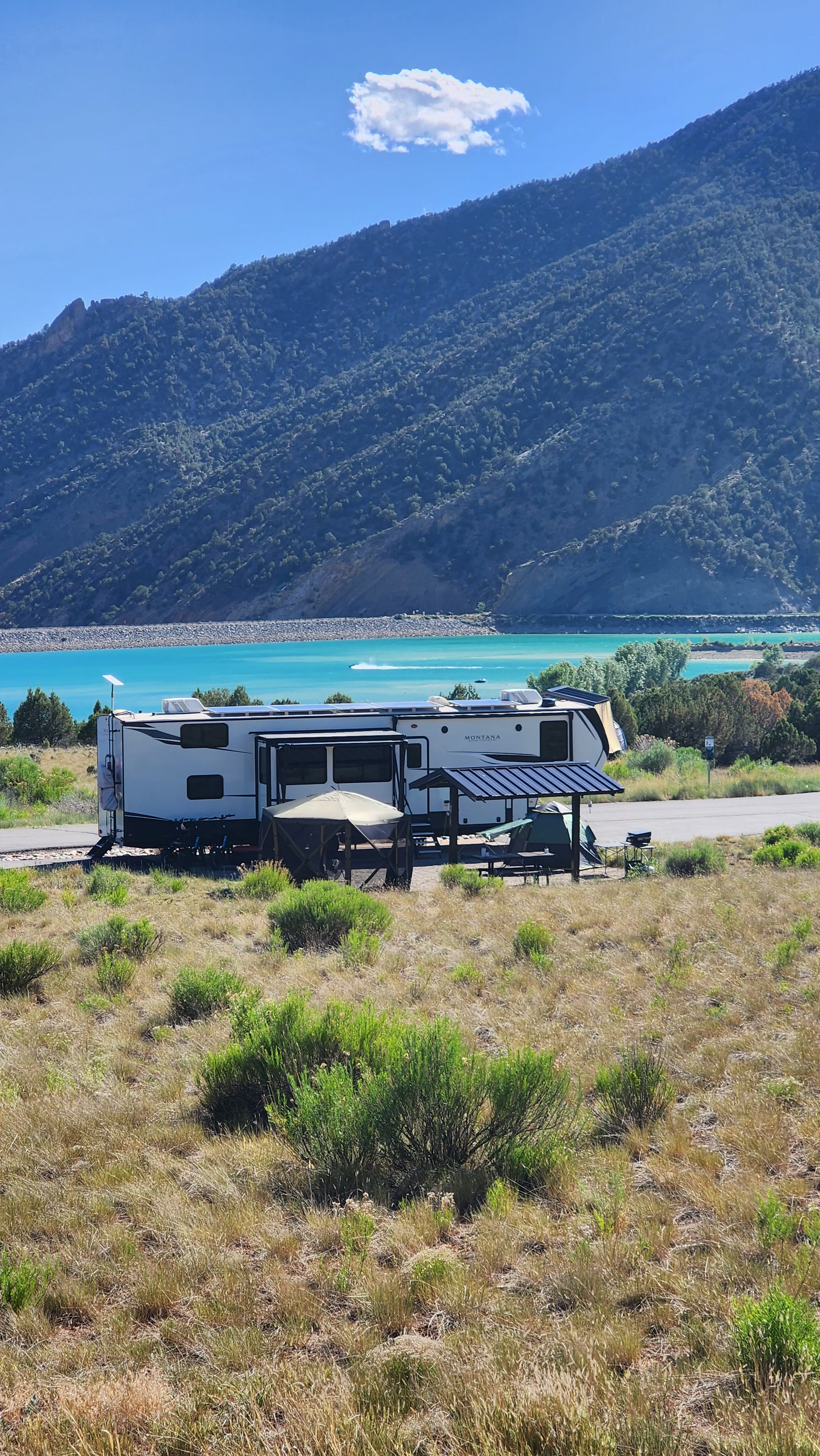 Kaylee and Steve Techau's Keystone Montana High Country at a campsite next to some mountains.