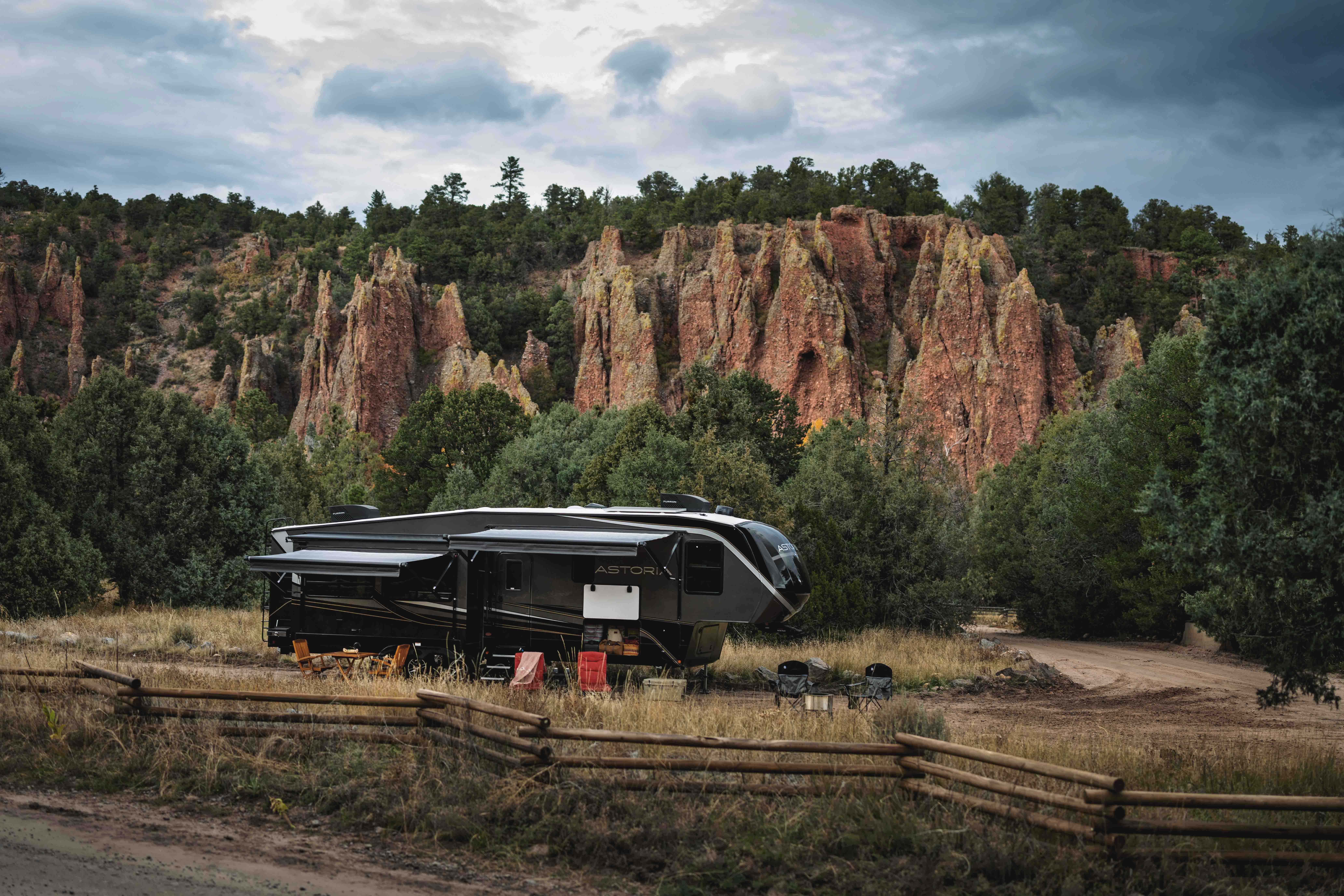 A Dutchmen Astoria fifth wheel camped next to rock formations.