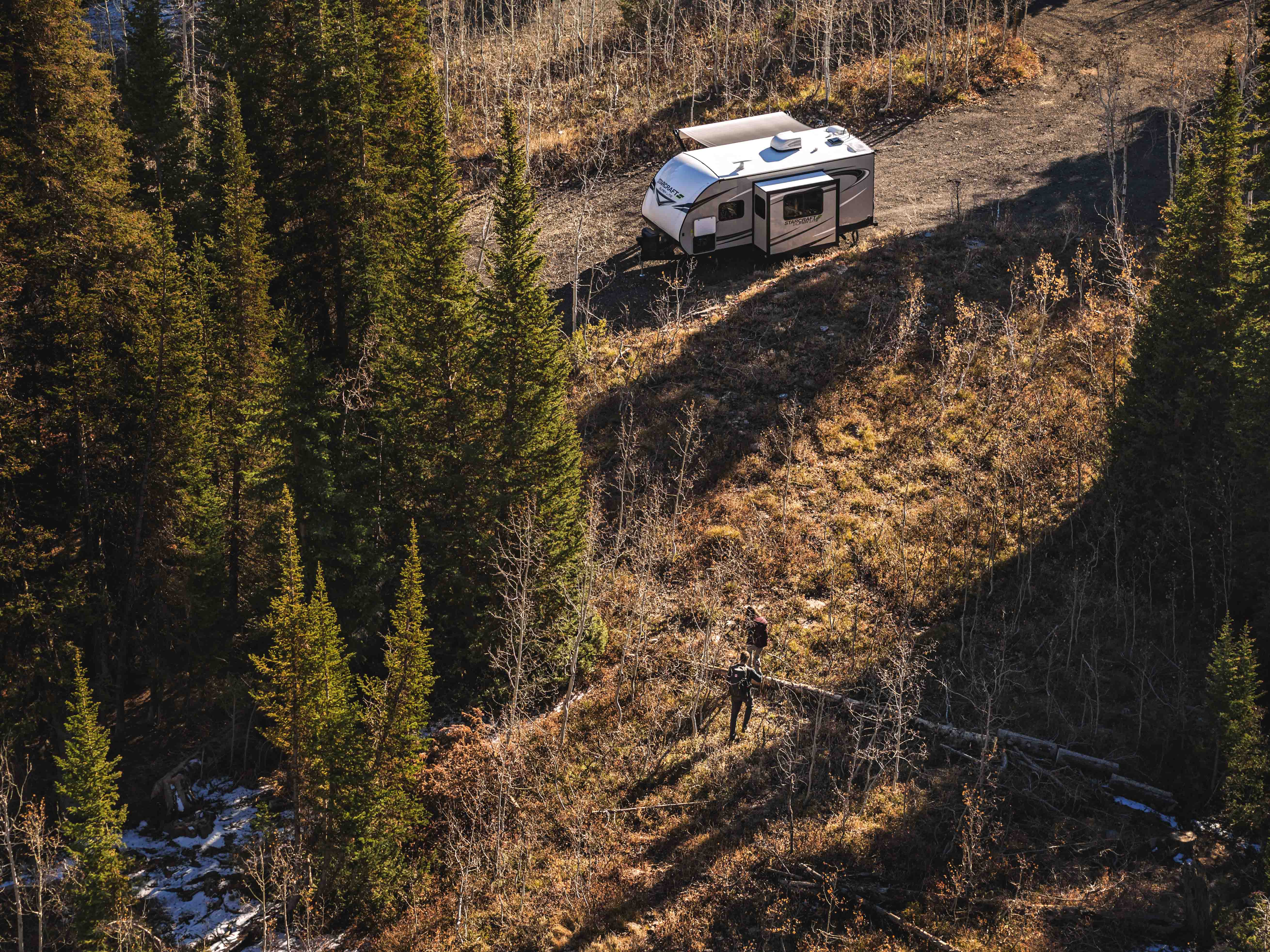 A Starcraft Super Lite travel trailer at a campsite.